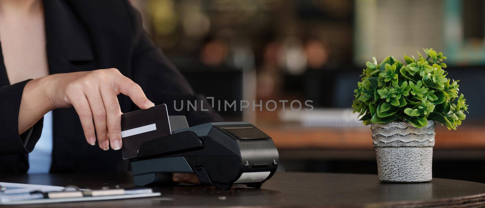 businesswoman hand pushing the button and swipe credit on terminal standing in shopping mall. shopping and retail concept.