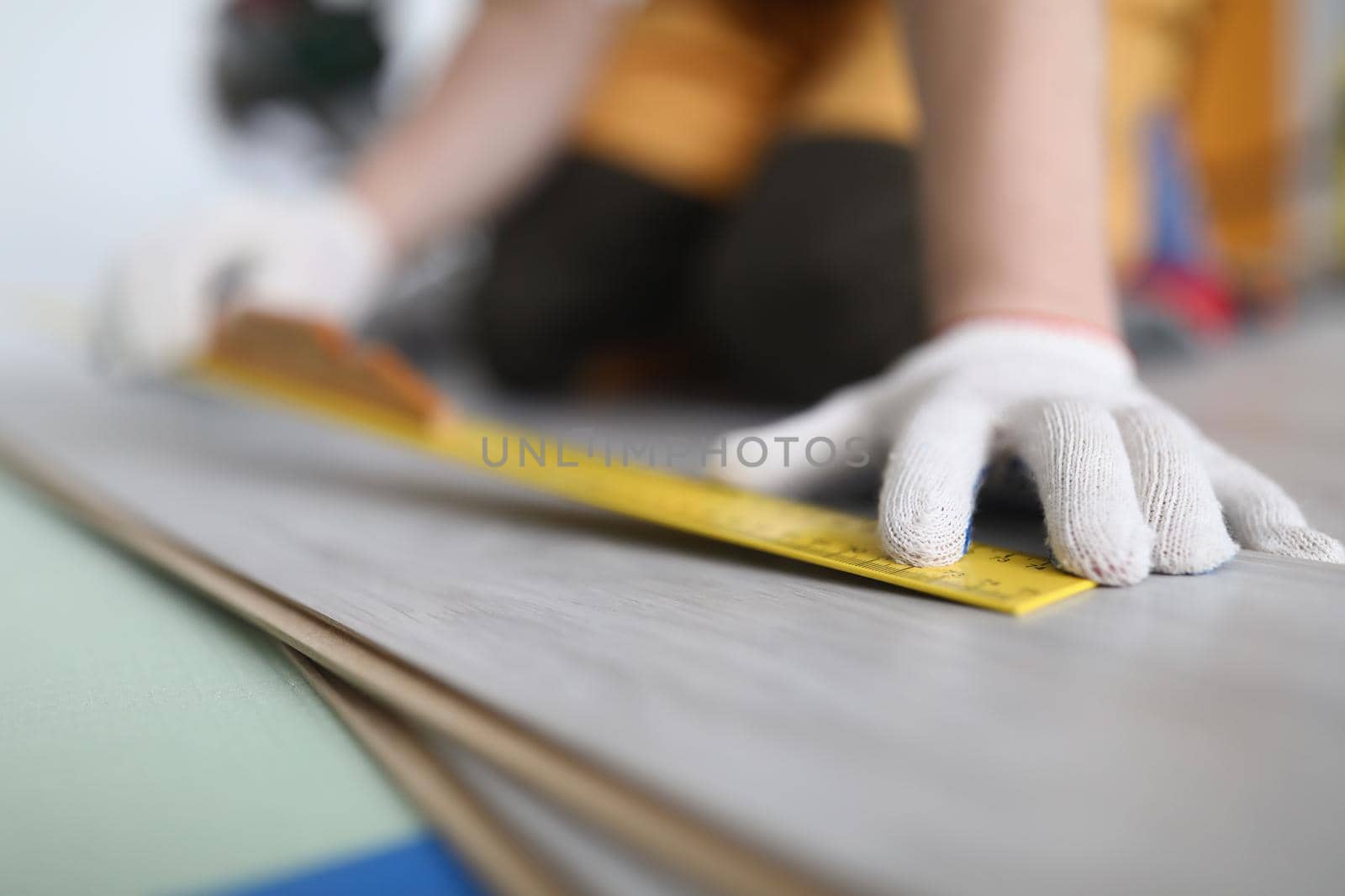 Close-up of professional male worker apply tape measure on wooden plank for further cutting. Foreman builder repair floor. Construction site, build concept