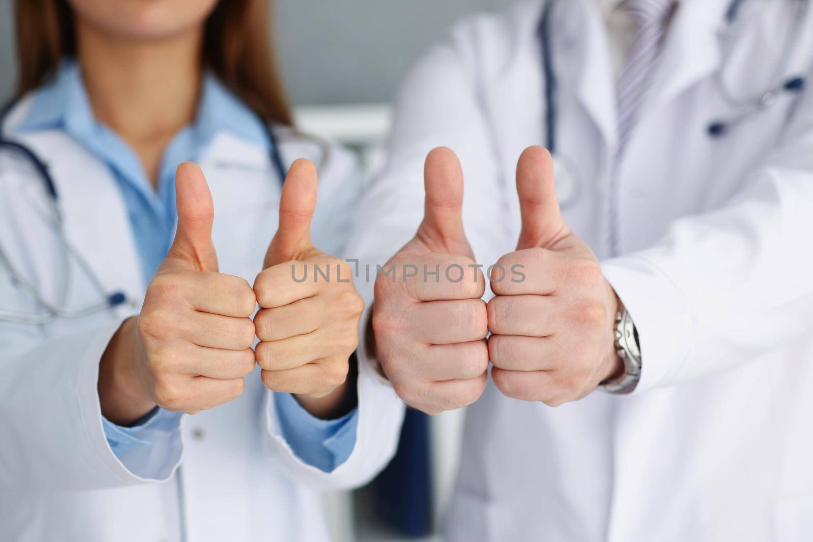 Close-up of doctors hands show ok or confirm sign with thumb up. High level therapy, great heal participation, healthy lifestyle, satisfied patient concept