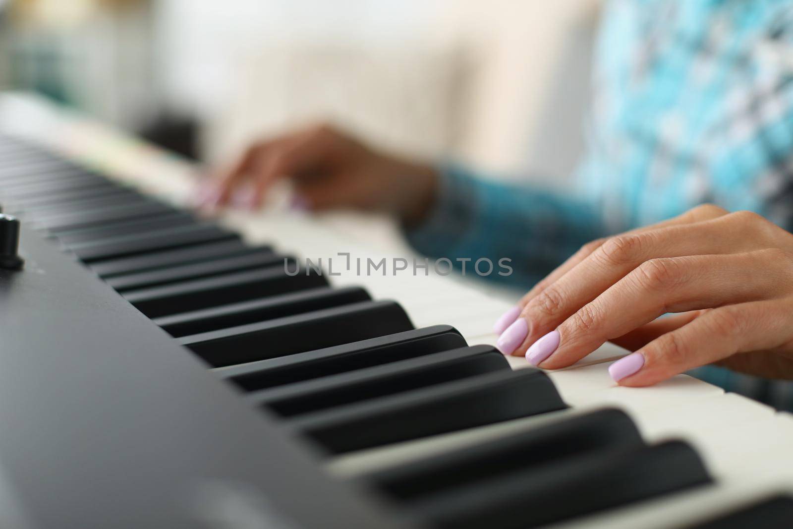 Close-up of womans hand touching white and black keyboards on piano. Talented girl playing song on musical instrument. Hobby, perform, solo, art concept