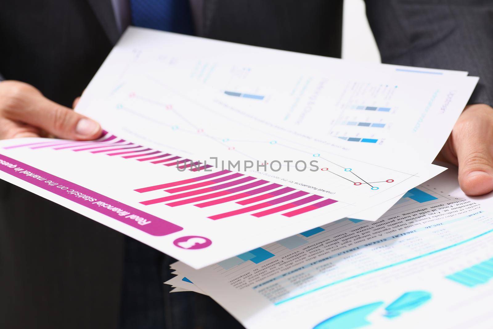 Close-up of businessman in suit holding agreement form or annual report in finance. Team leader, business, career, development, economy, growth concept