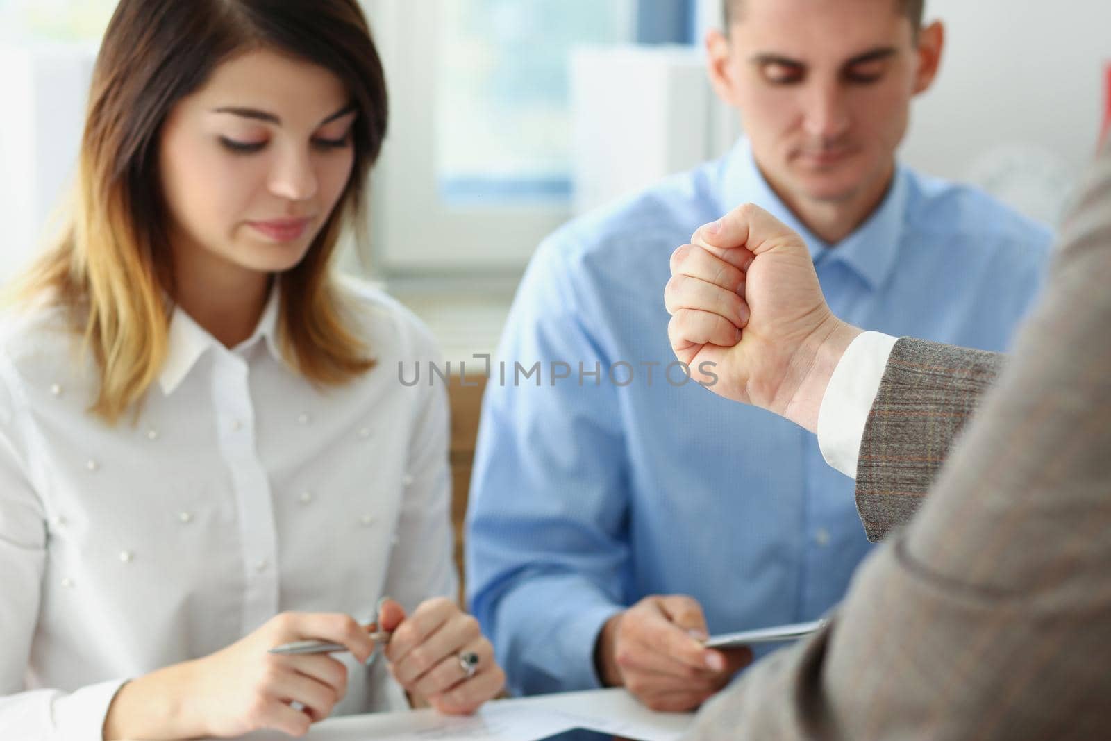 Portrait of businessman hand threatens his hired employees, coworkers looking down, feeling guilty. Strict boss give warning to clerks. Discipline concept