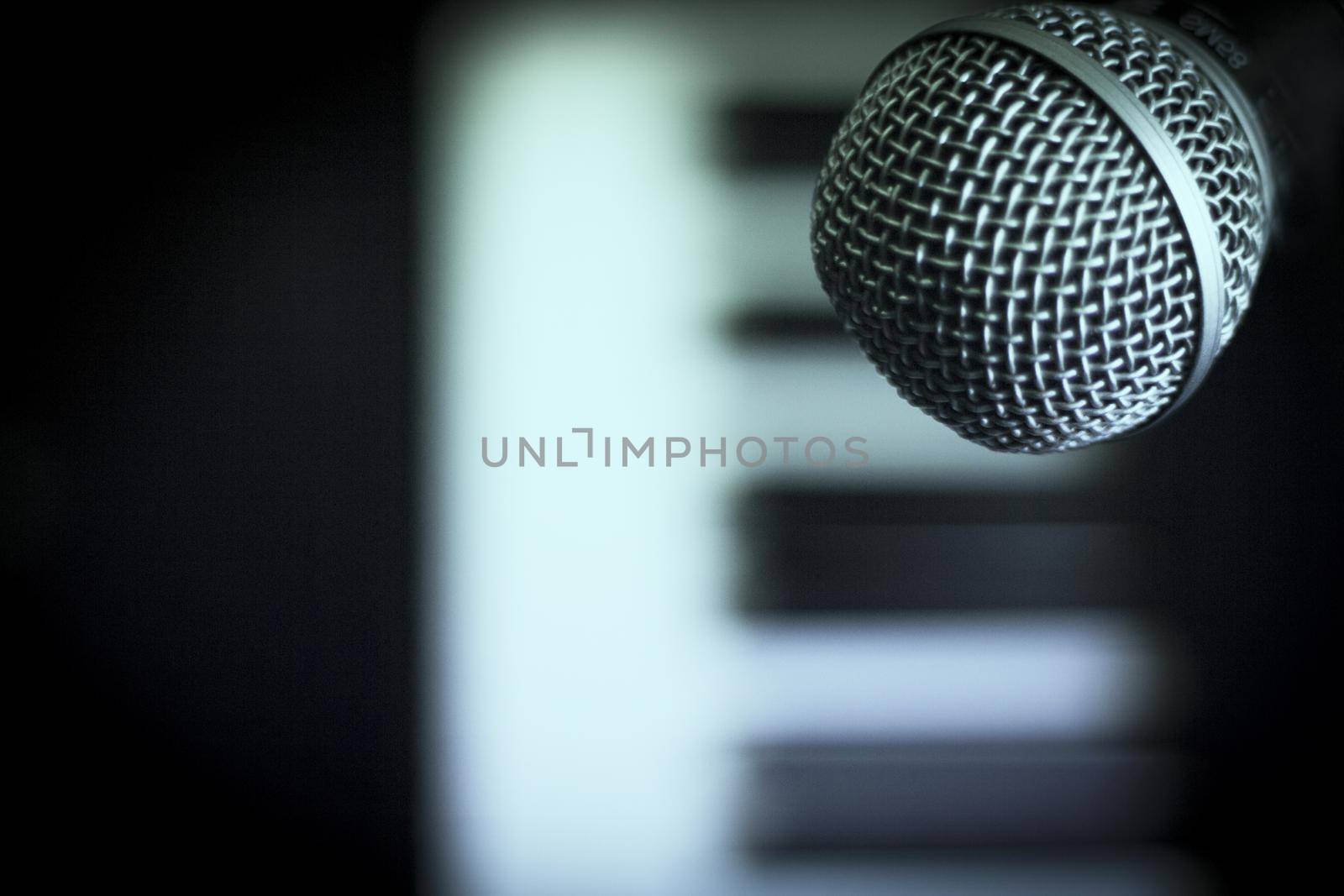 Microphone over piano keys in dim light. No people