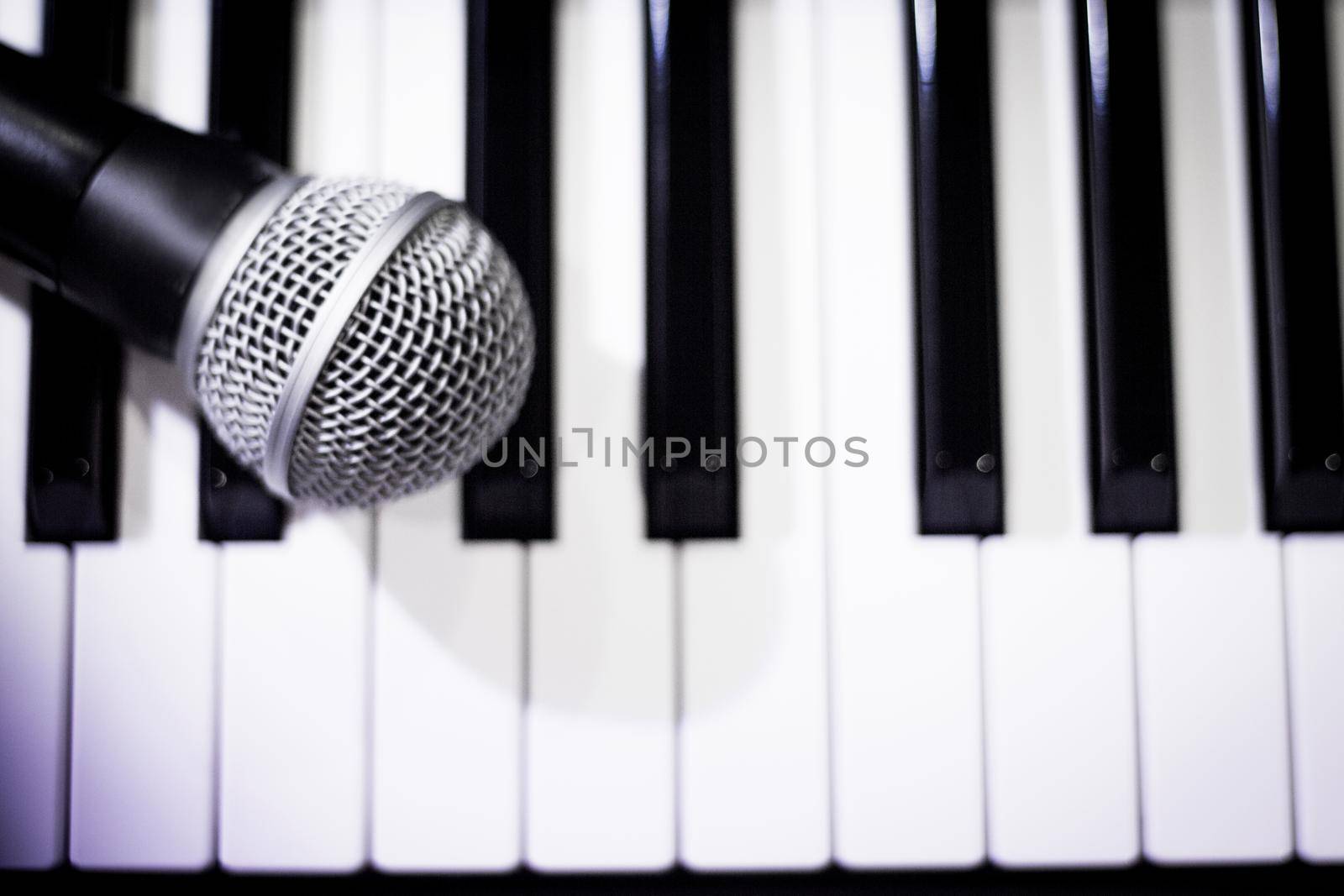 Microphone over piano keys in dim light. No people