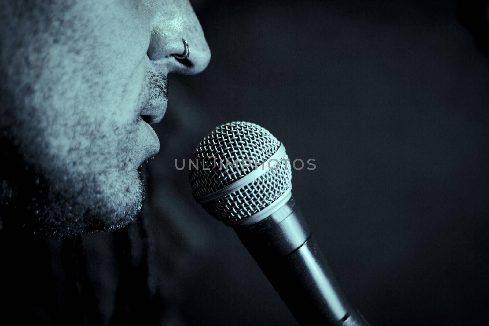 Singer man with round microphone on dark background by GemaIbarra