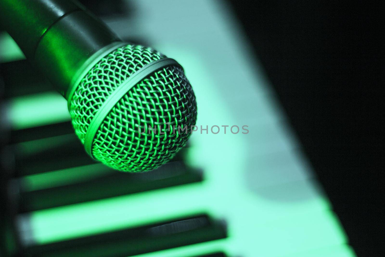 Microphone over piano keys in dim light. No people