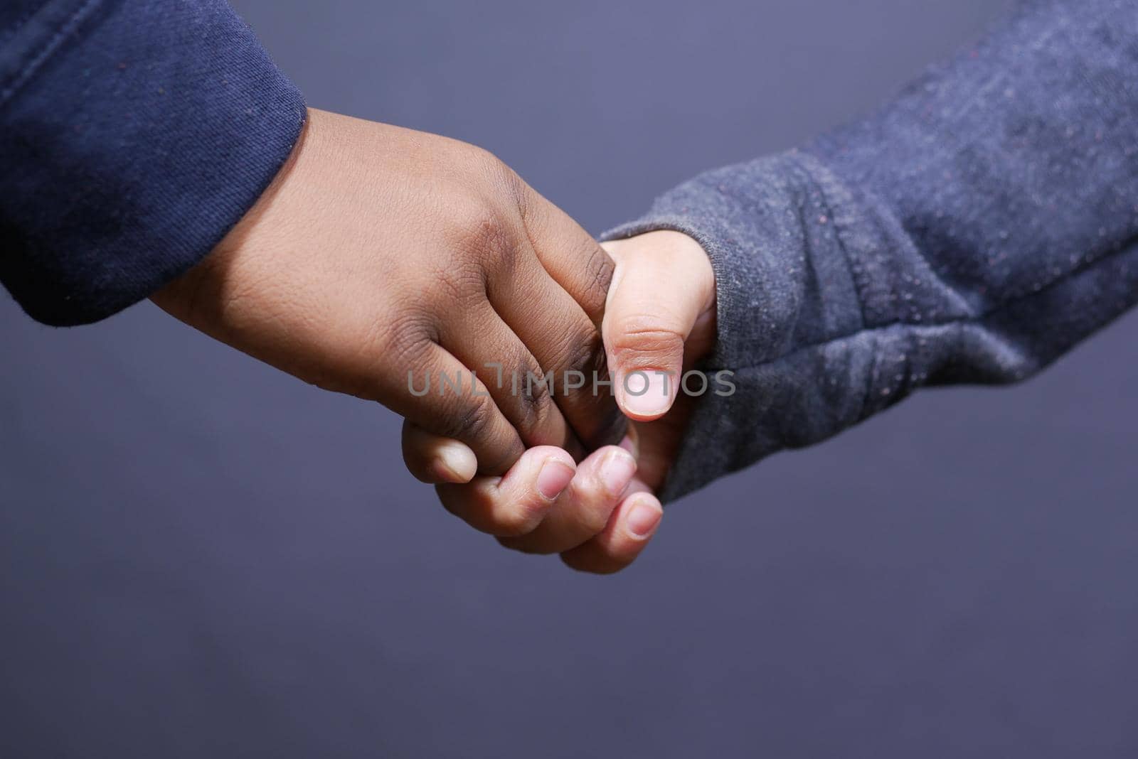 detail shot of child girl holding hand of her bother ,