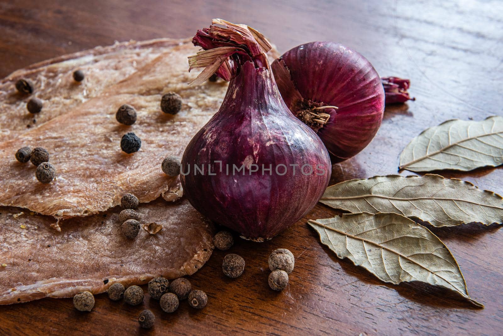 Jerky with spices, onions and herbs on an old wooden table. Beer snack by karpovkottt