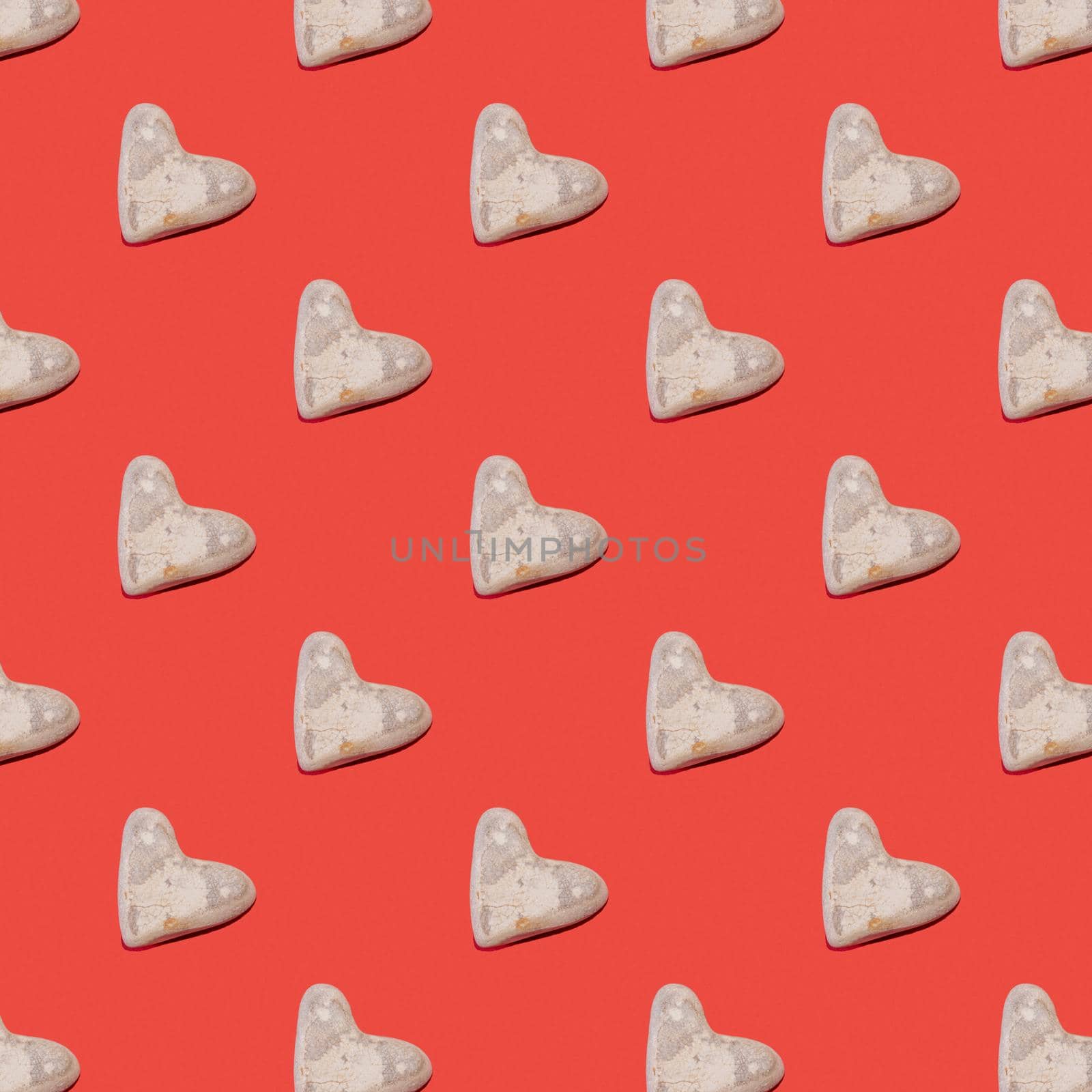 Pattern of stones in the shape of a heart of love for Valentine's Day on a red background by karpovkottt