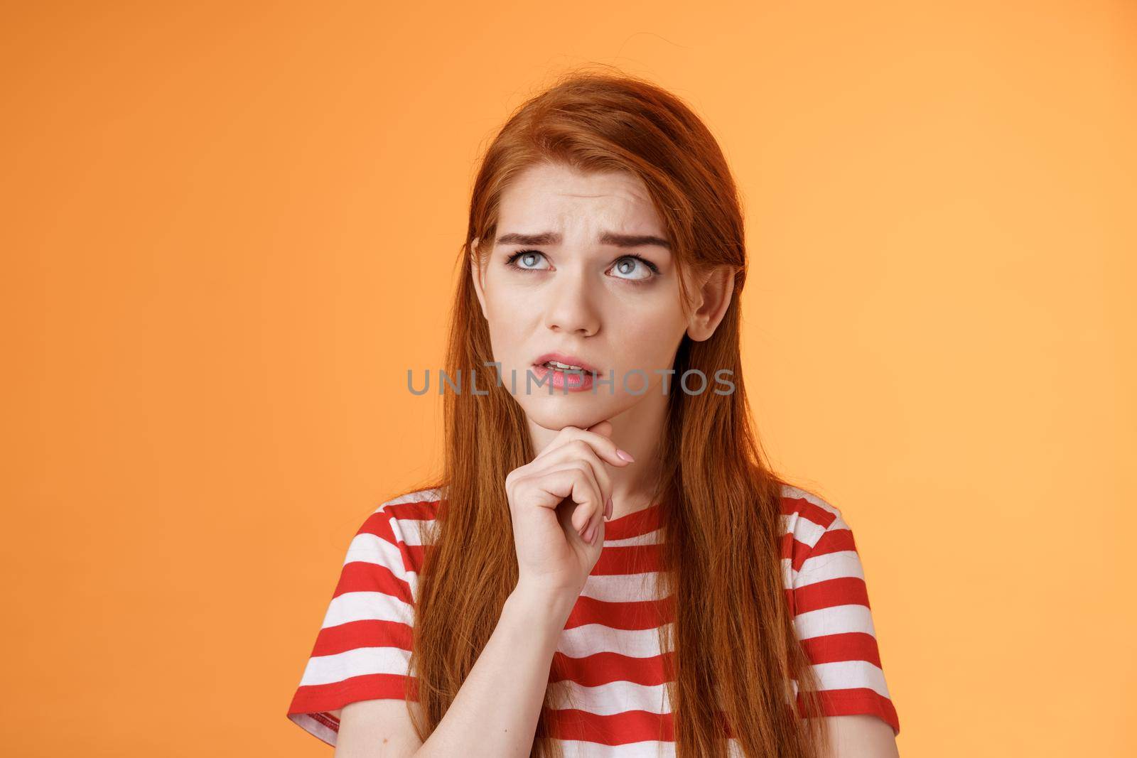 Perplexed redhead woman trying make calculations mind, frowning focused, look up puzzled thoughtful, touch chin, thinking, pondering important decision, make choice, solve problem by Benzoix