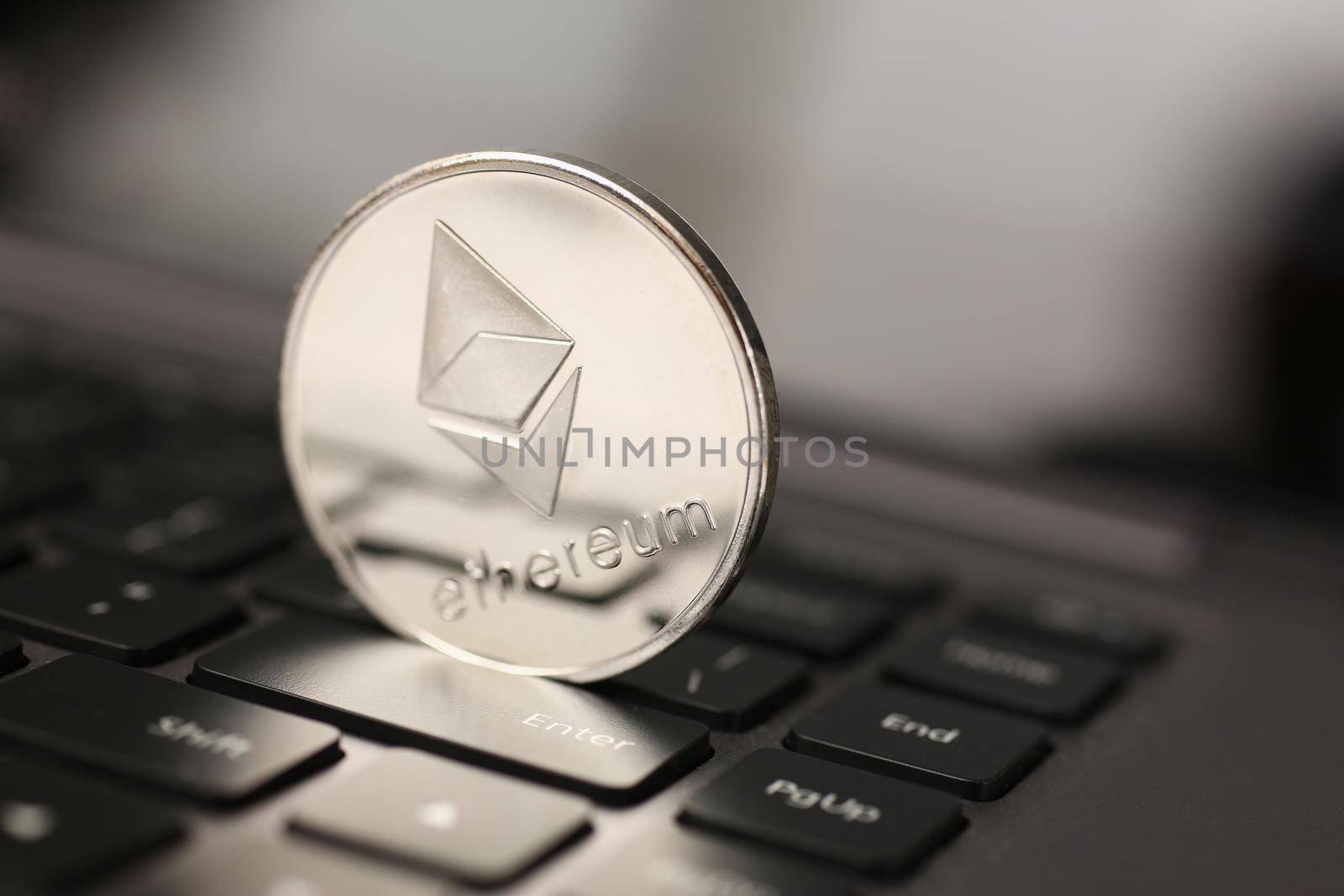 Ethereum silver coin on laptop pc keyboard by kuprevich