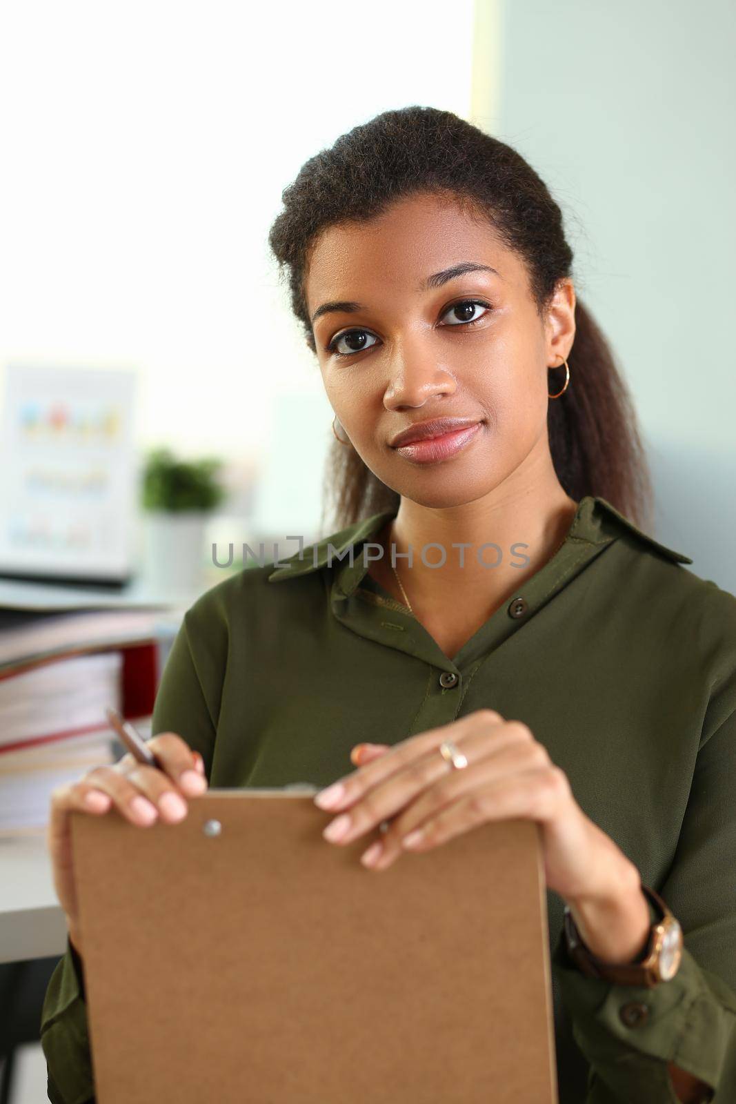 Beautiful black smiling businesswoman portrait holding business documents by kuprevich