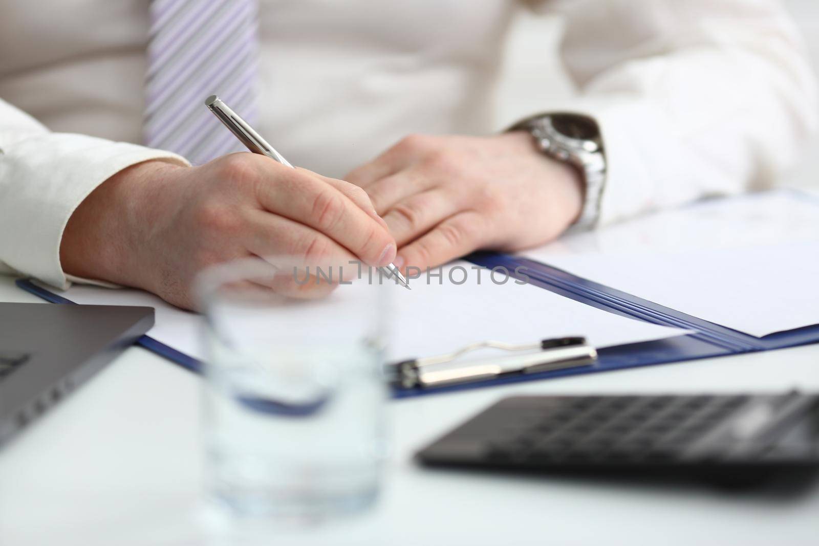 Man hand holds pen and fills out schedule of working day. Financial investment expert consultation concept