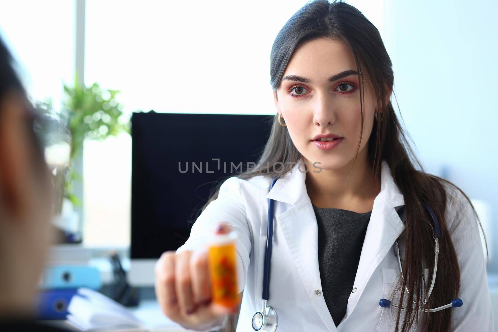 Female medicine doctor hand hold jar of pills in clinic. Medicines concept
