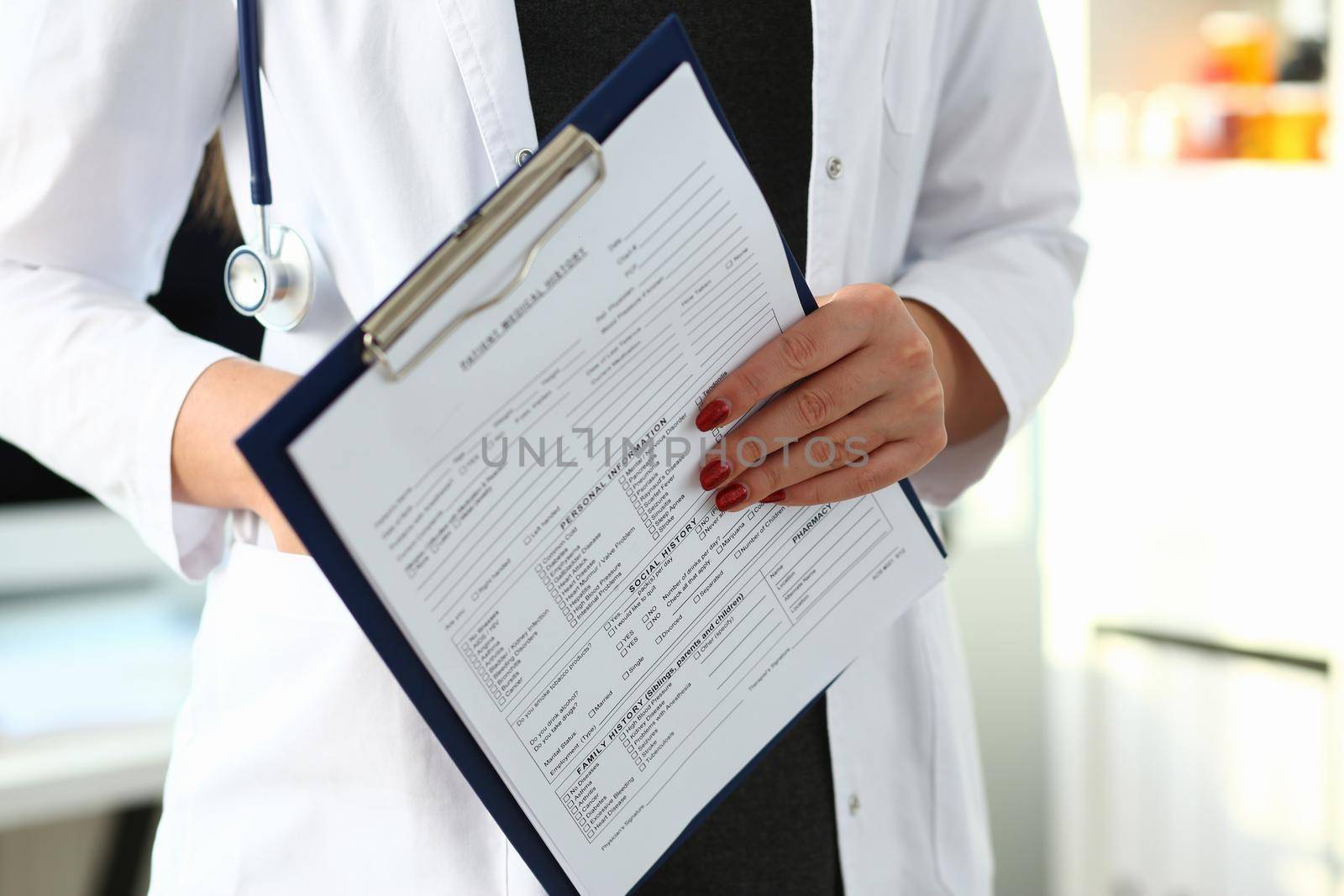 Woman doctor hand holds medical card with patient history. Medical examination and diagnosis posting concept