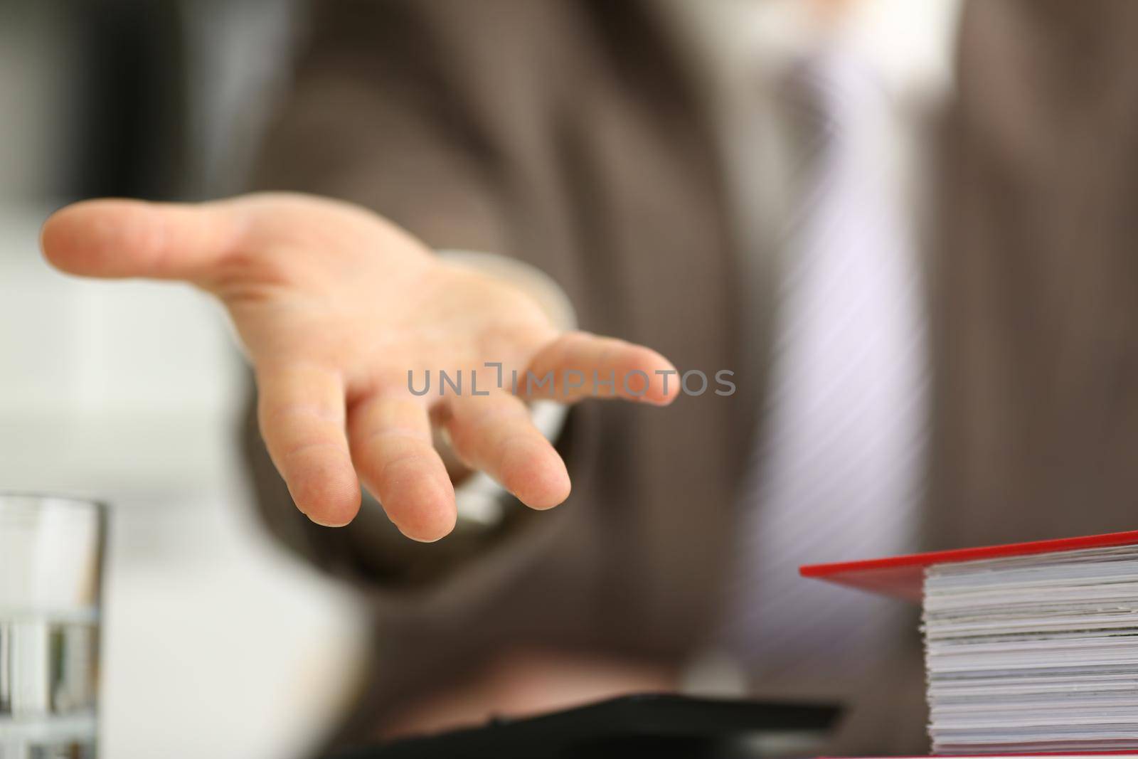 Man in suit extends open hand forward. Friendly open gesture concept