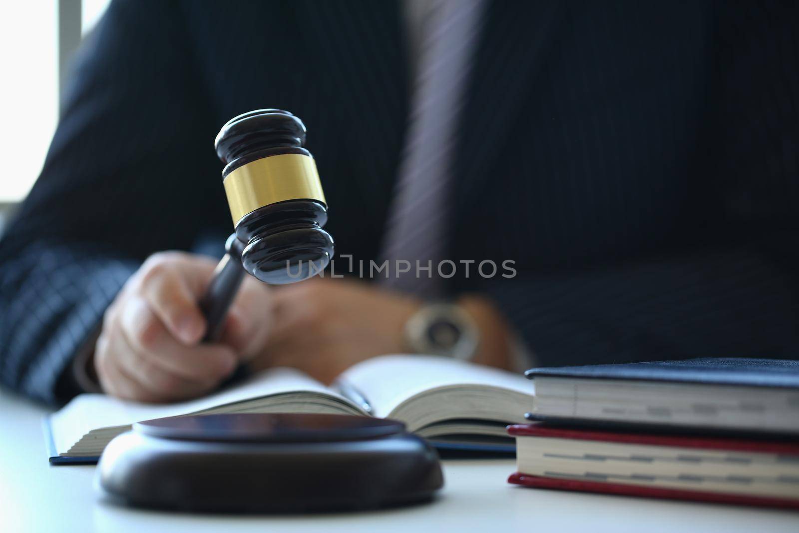 Male judge in courtroom hits with hammer. Court session on consideration of criminal case in court concept