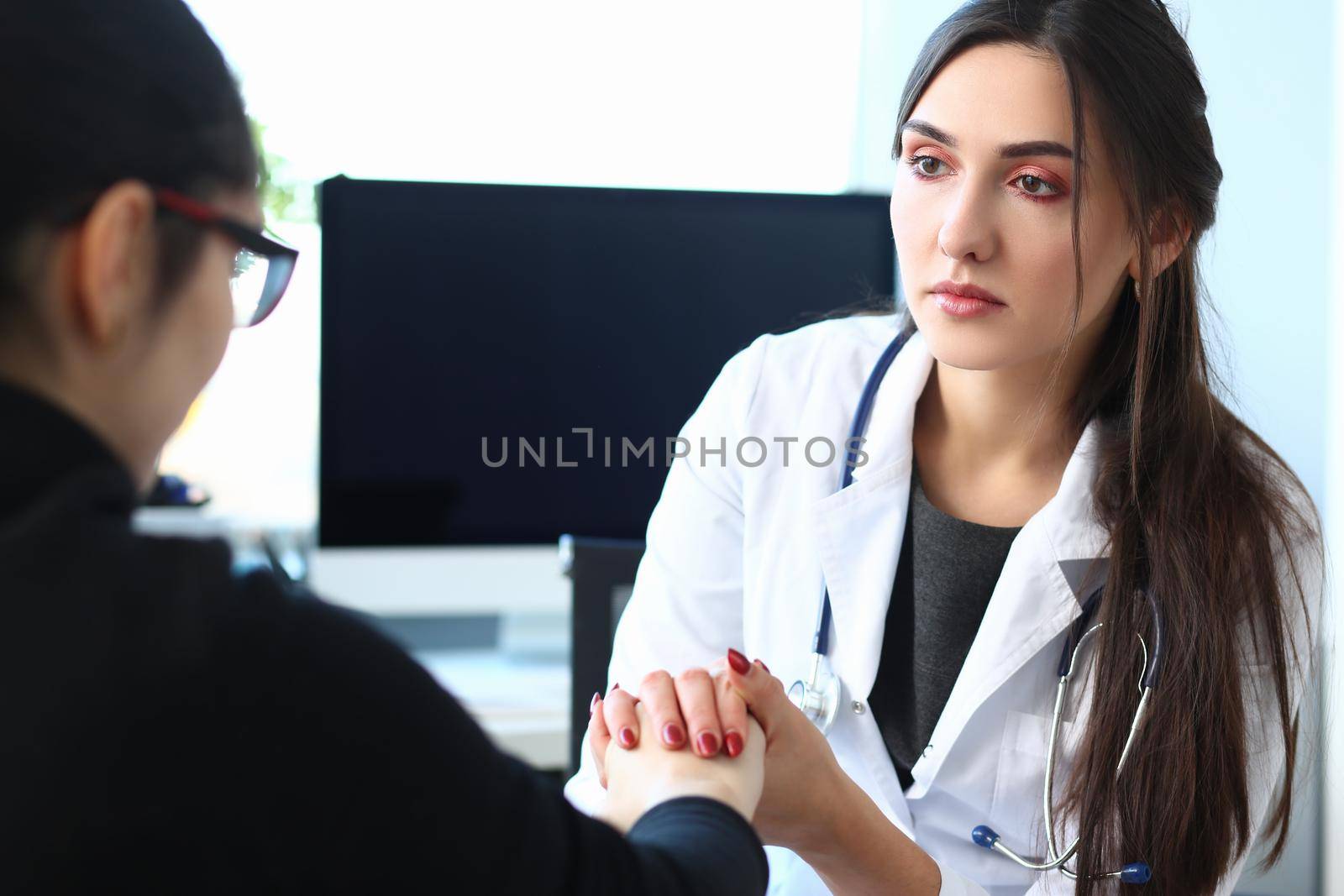 Woman doctor holds patient hand, expressing condolences and sympathy by kuprevich