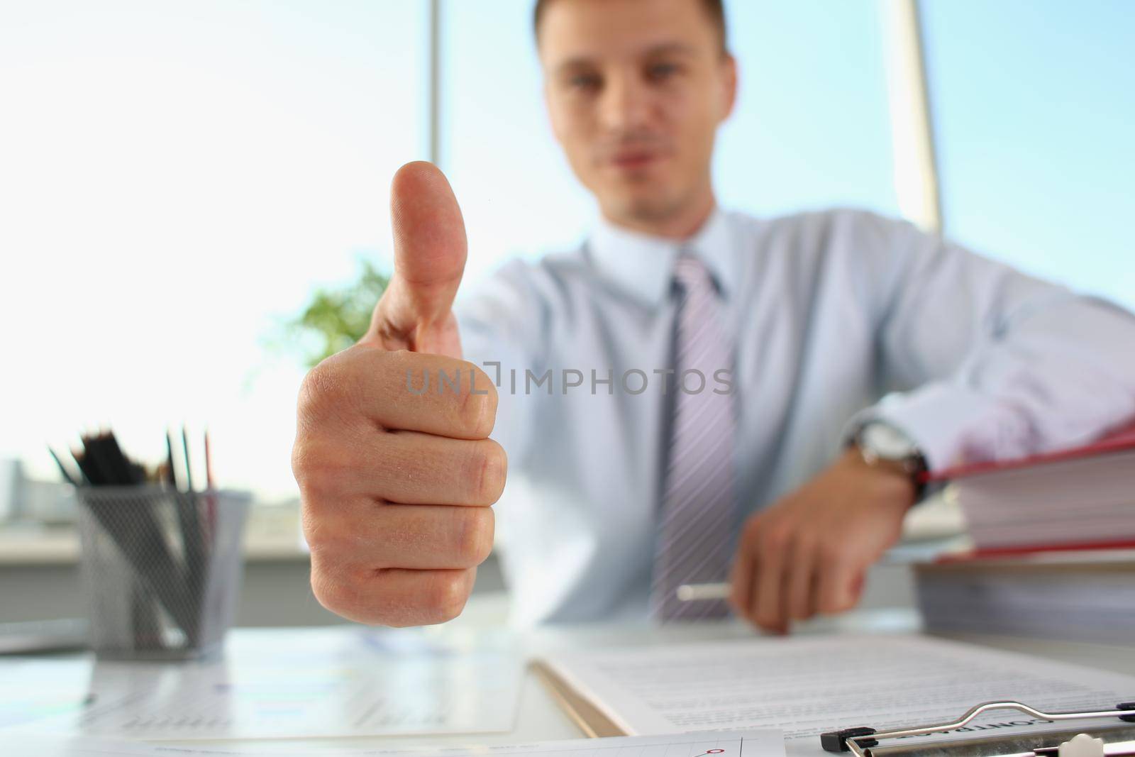 Businessman makes thumbs up gesture. Consulting and business advice concept