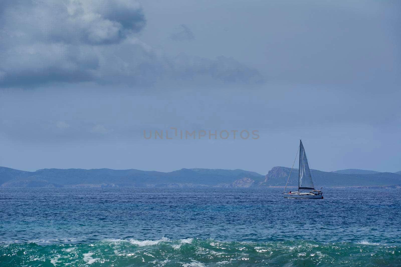 Small sailboat sailing in front of an island by raul_ruiz