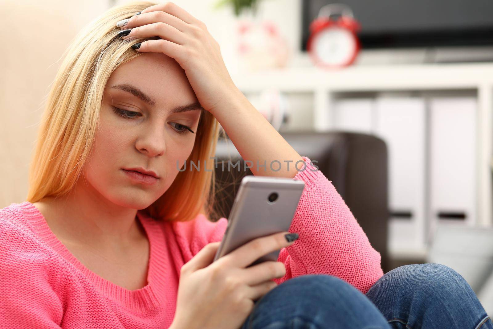 Sad woman looks at smartphone screen. Breakup and chatting concept