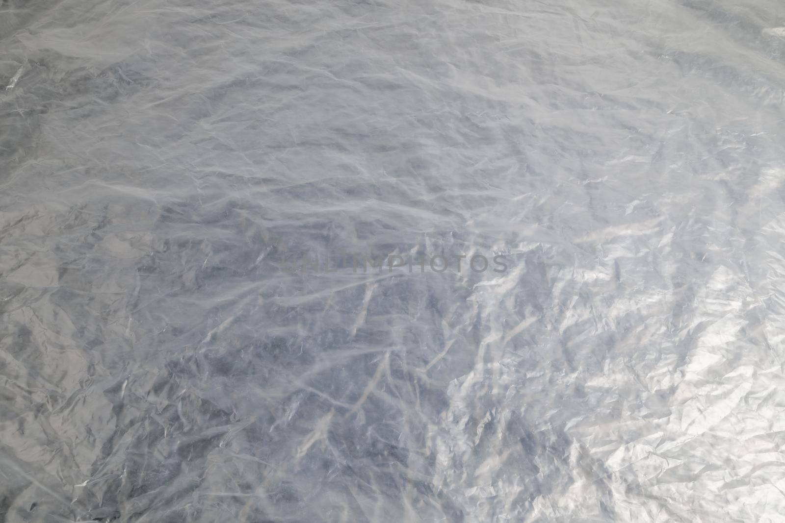 full frame background of flat crumpled semi-transparent polyethylene film.