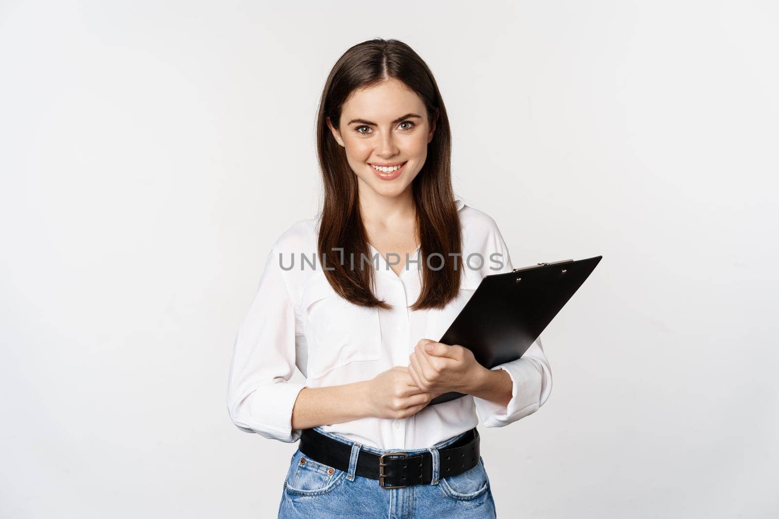 Corporate woman, businesswoman holding clipboard with documents in office, smiling at camera, white background.