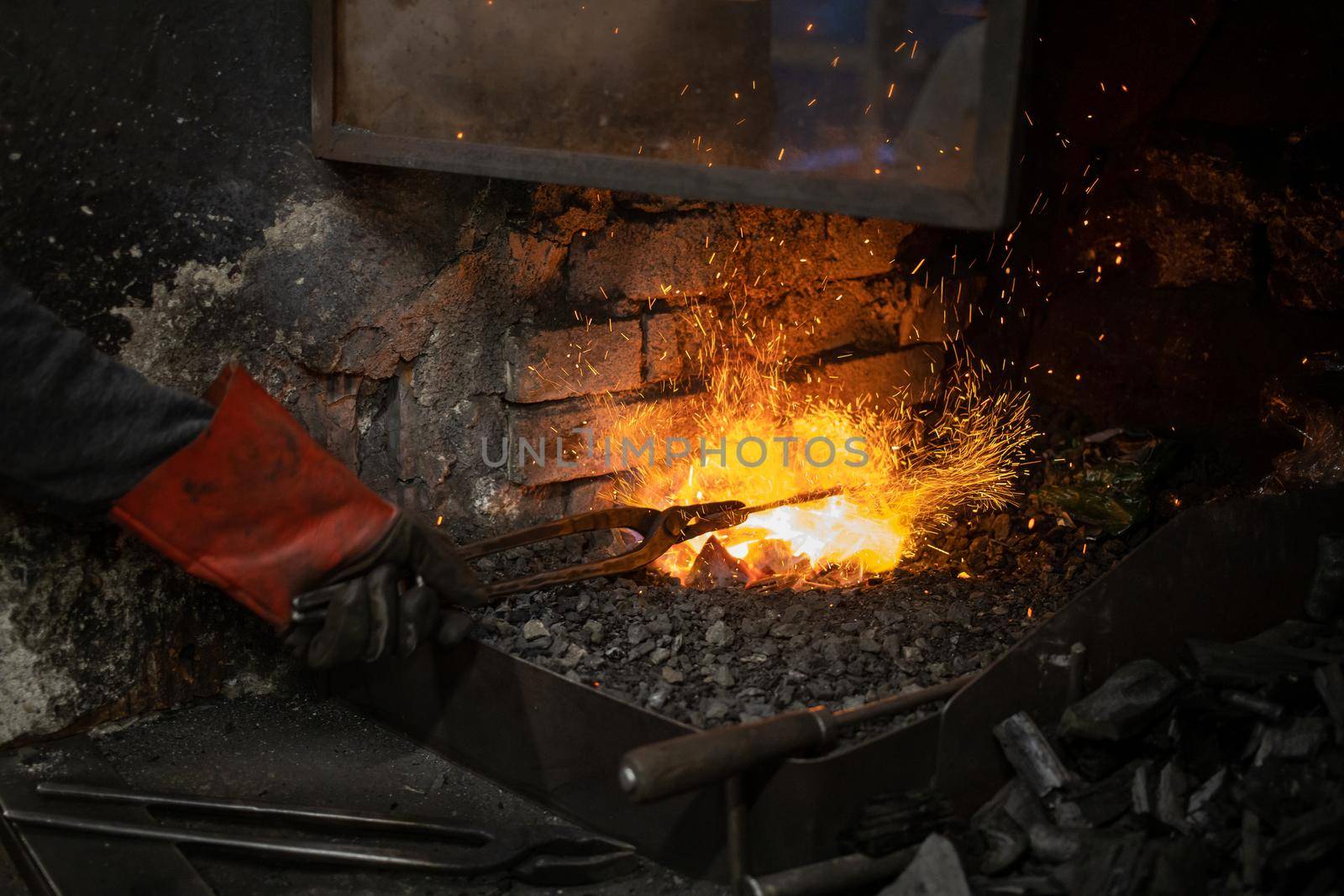 blacksmith warming blank metal on coal fire. High quality photo