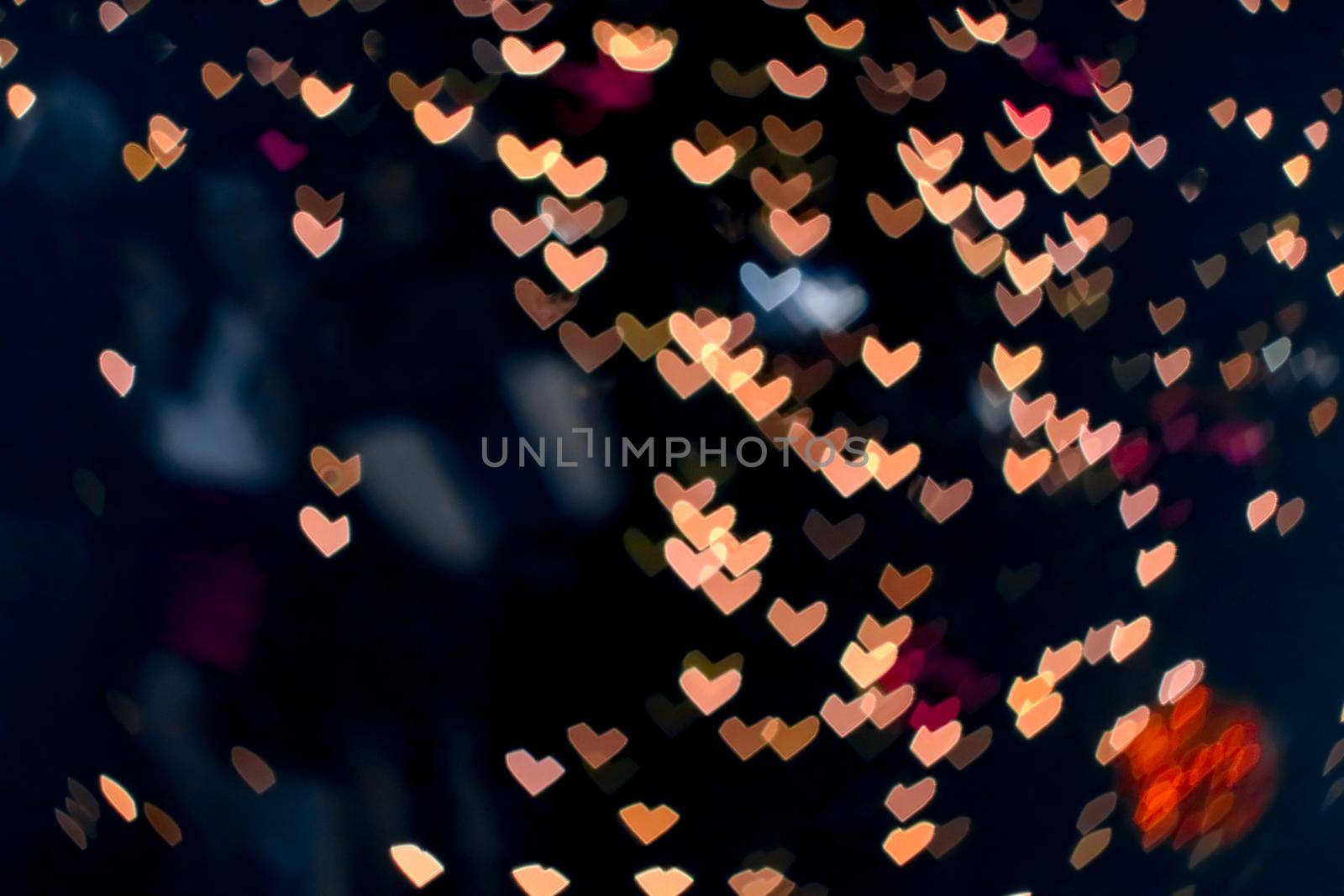orange bokeh and blur heart shape love valentine colorful night light at shopping mall