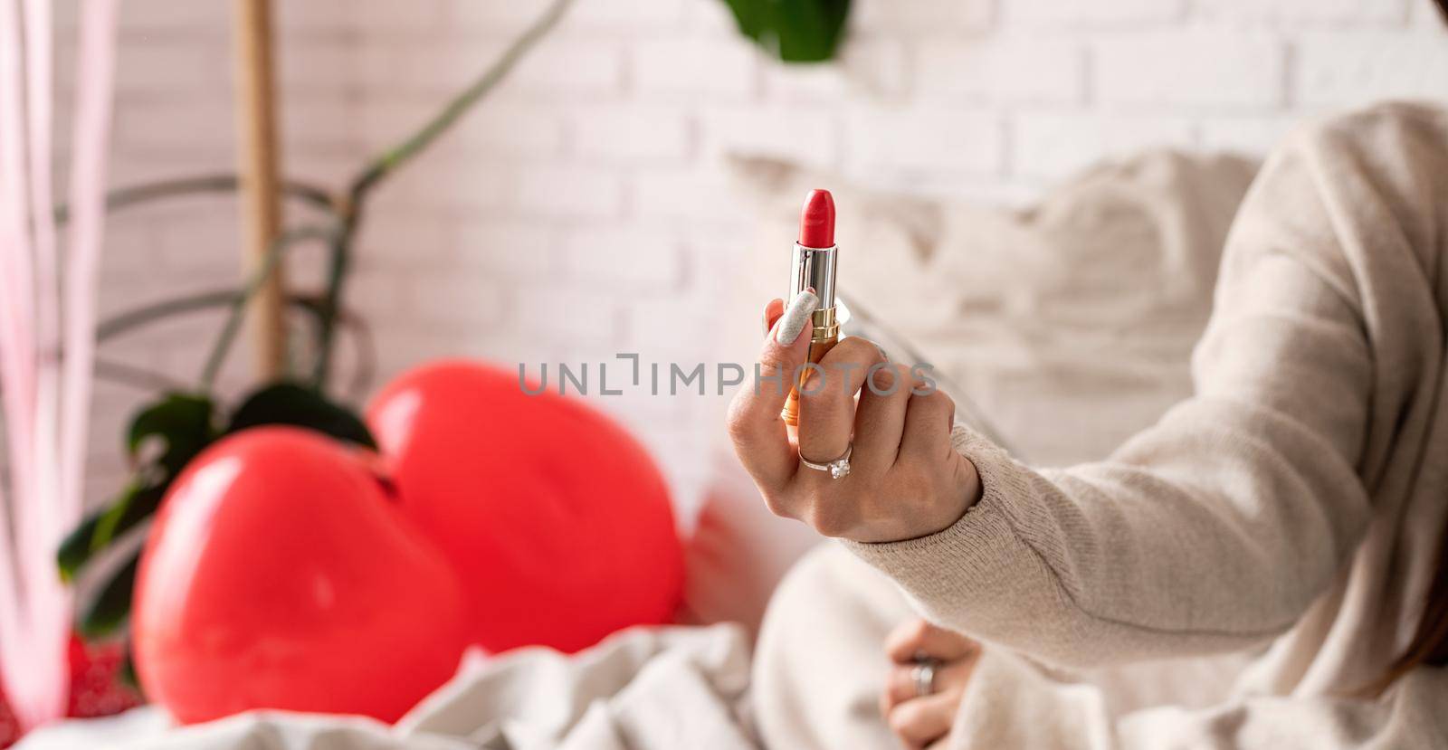 woman hand holding red lipstick by Desperada