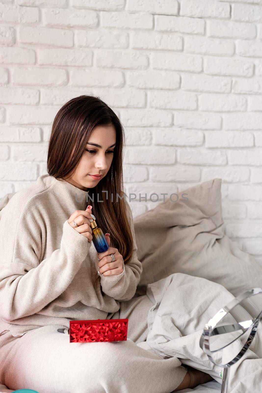 Valentine's day, Women's day. Brunette young Woman celebrating valentines day, sitting on the bed making up