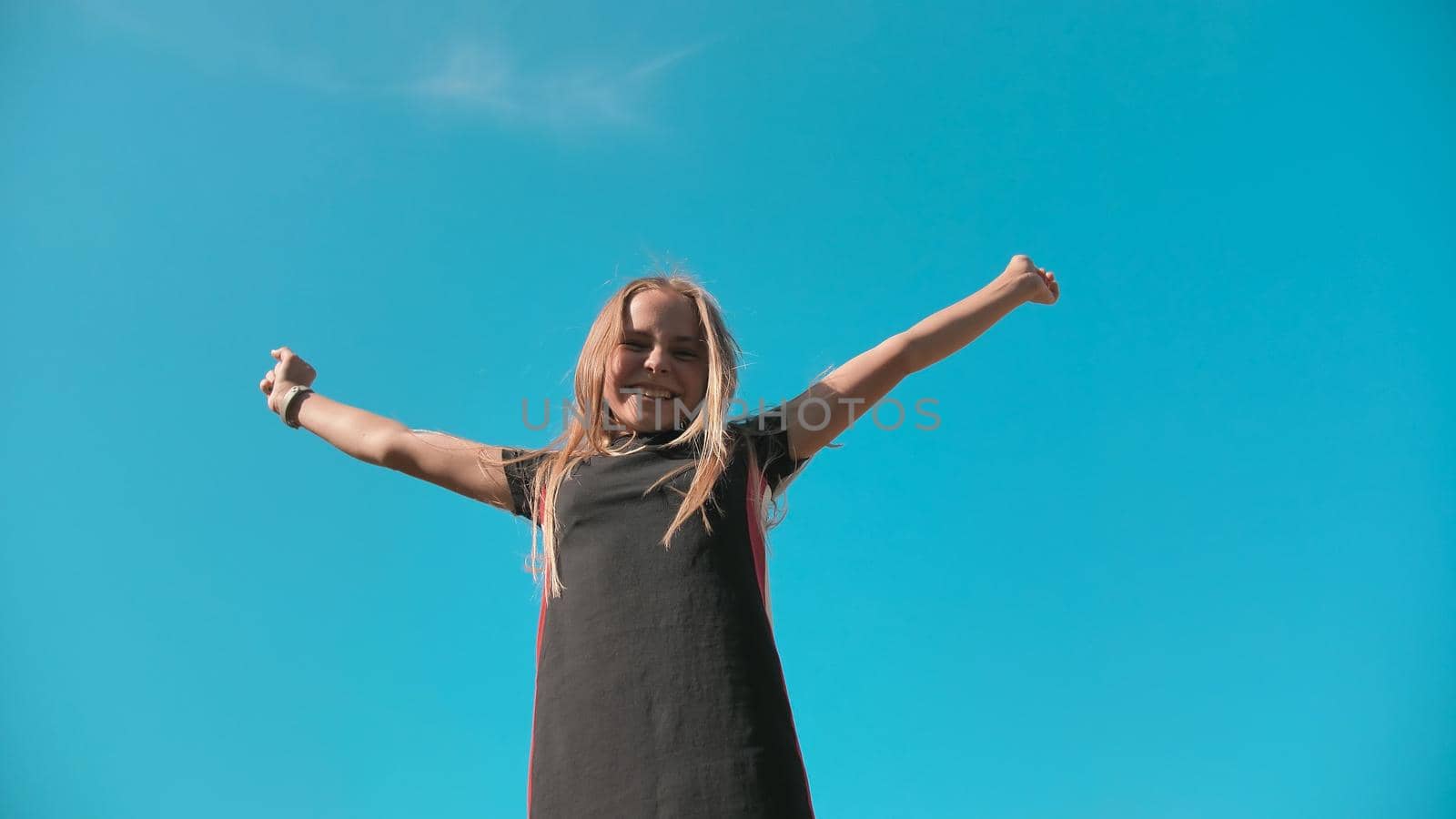 Happy jumping girl on a background of blue sky. by DovidPro