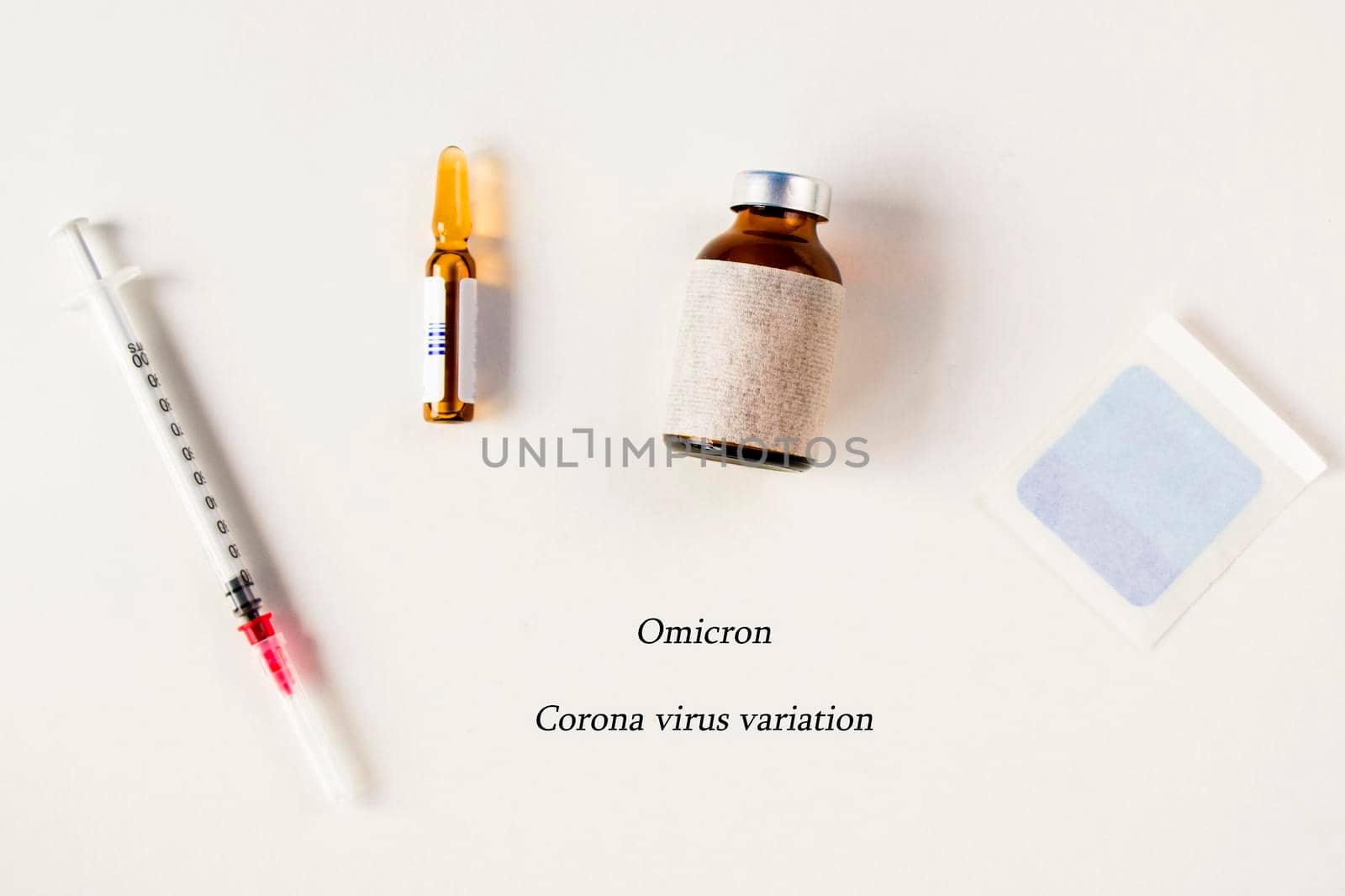 Omicron, corona virus variation. Vaccine ampule and needle on the white background, virus vaccine