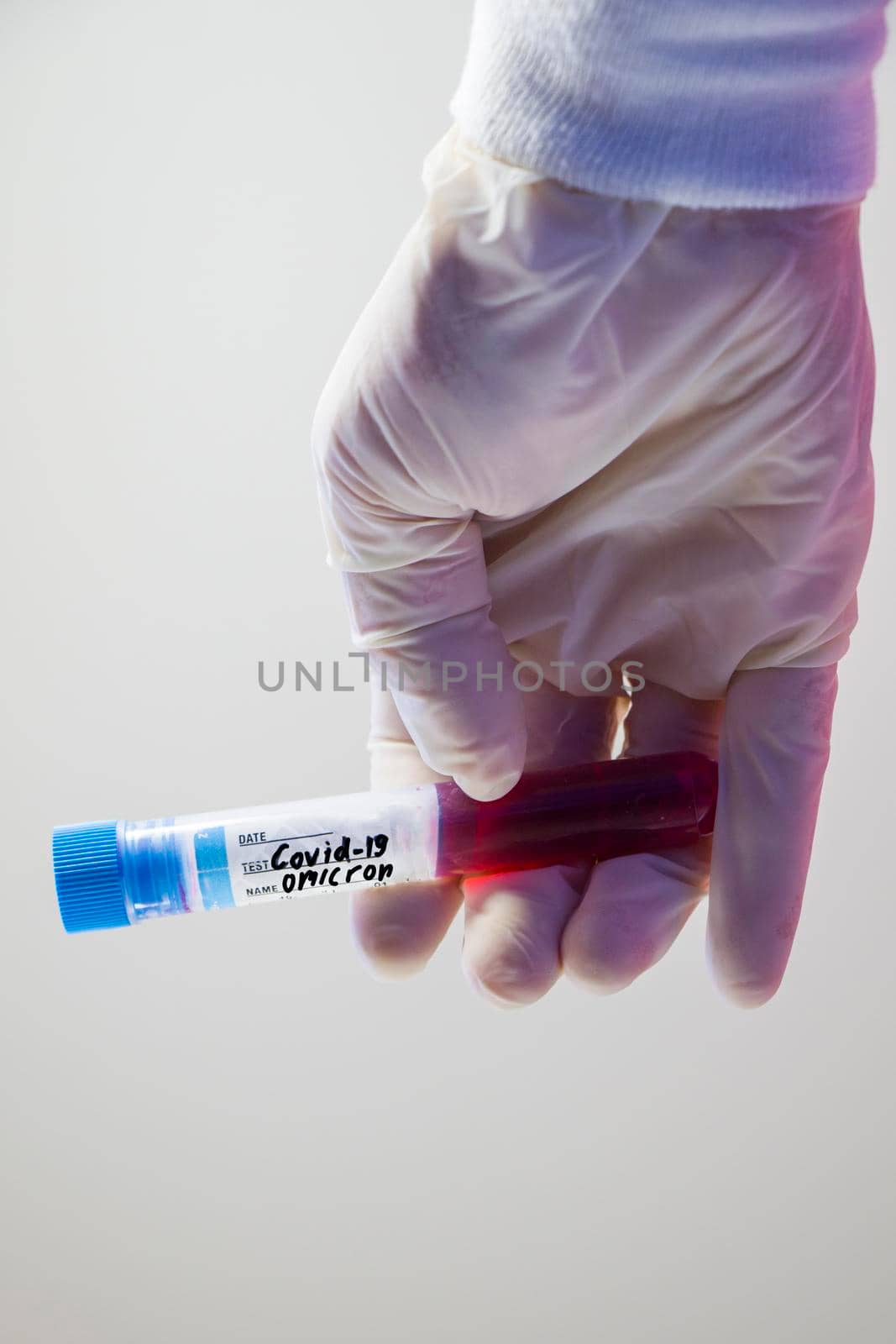 Omicron, corona virus variation. Blood test tube and doctors hand