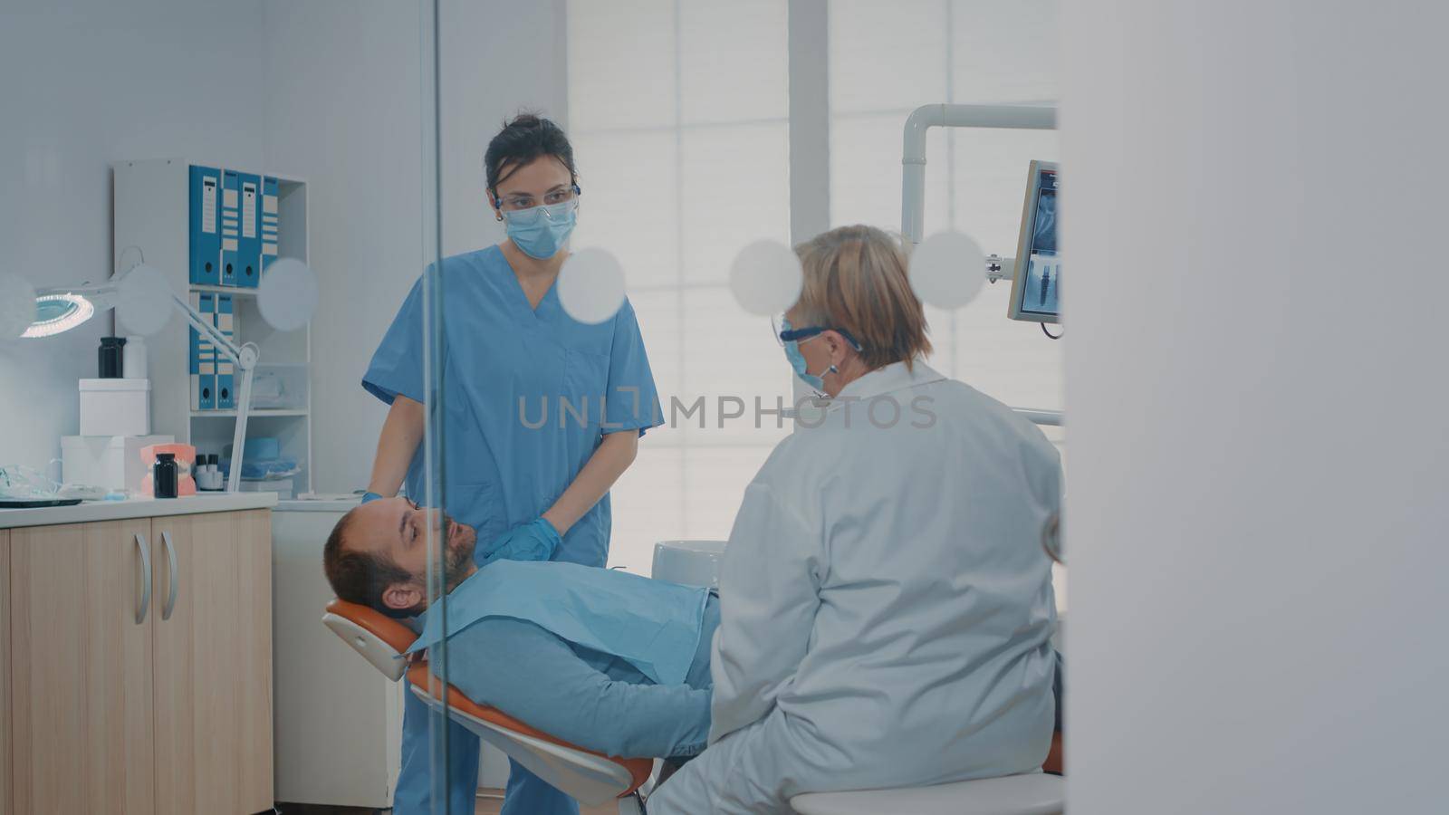 Orthodontist using dental tools to do teeth examination by DCStudio