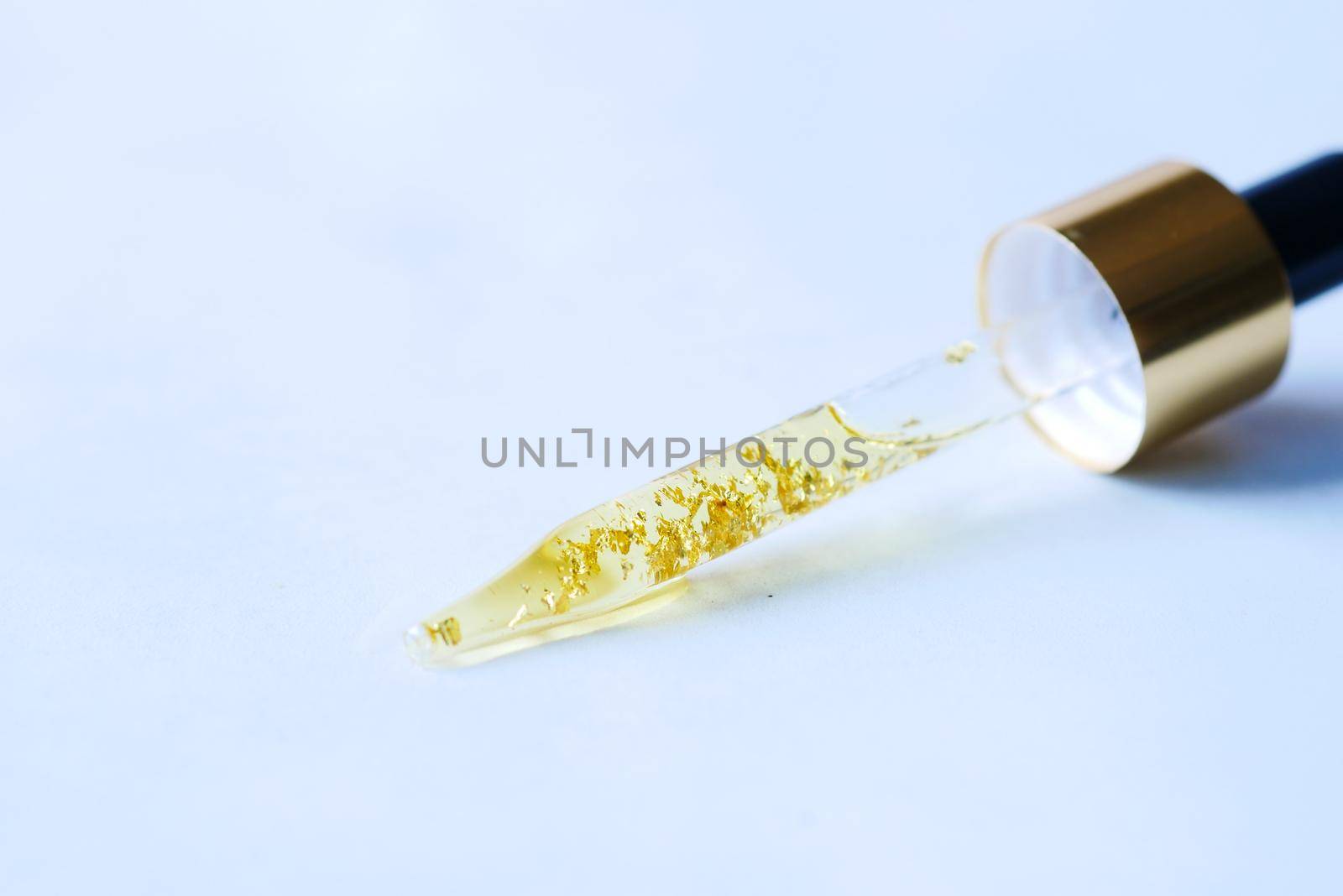 Drop falls from a pipette into a cosmetic bottle,