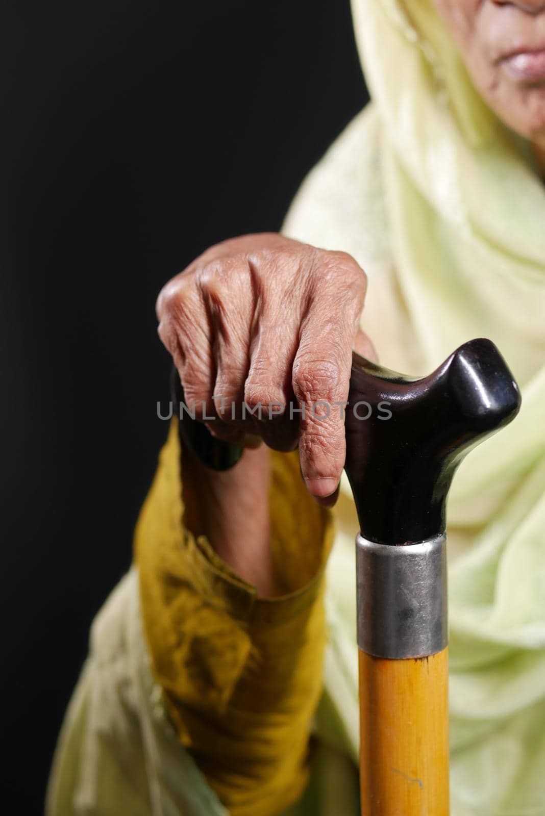 senior women hands on walking stick, by towfiq007