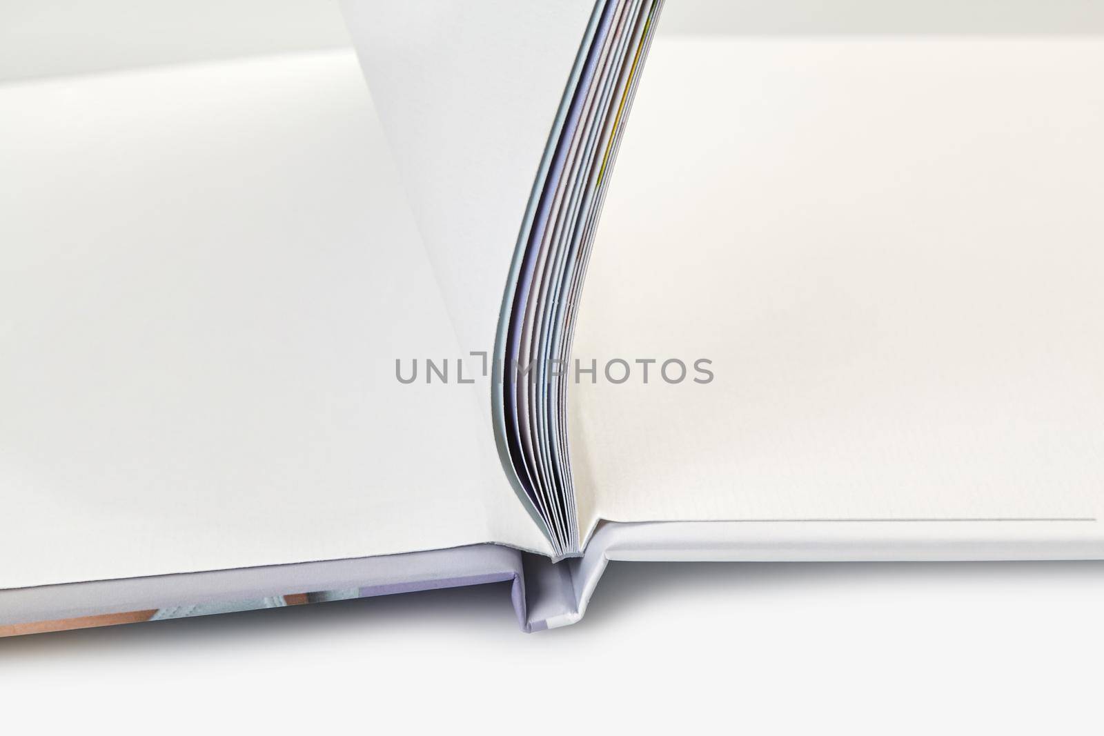 Open photo book with hardback and blank pages on white studio background. Close up, copy space by nazarovsergey