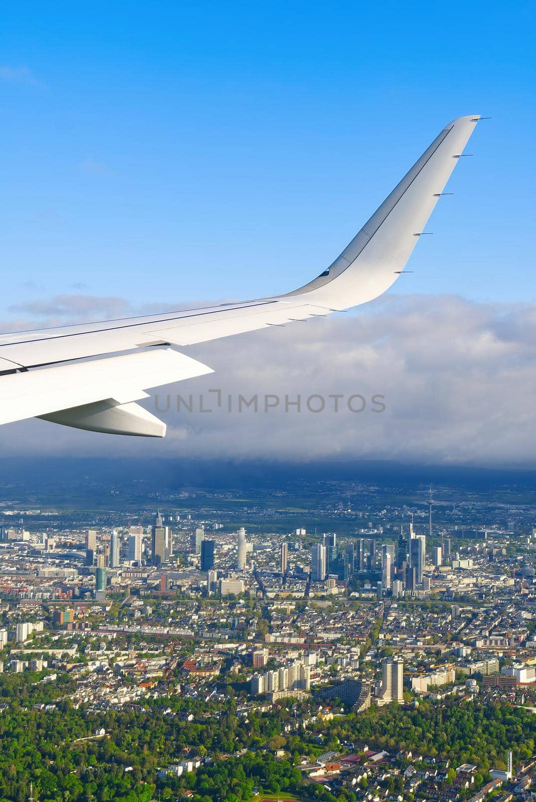 View of airplane white wing flying in blue sky over clouds. Travel concept