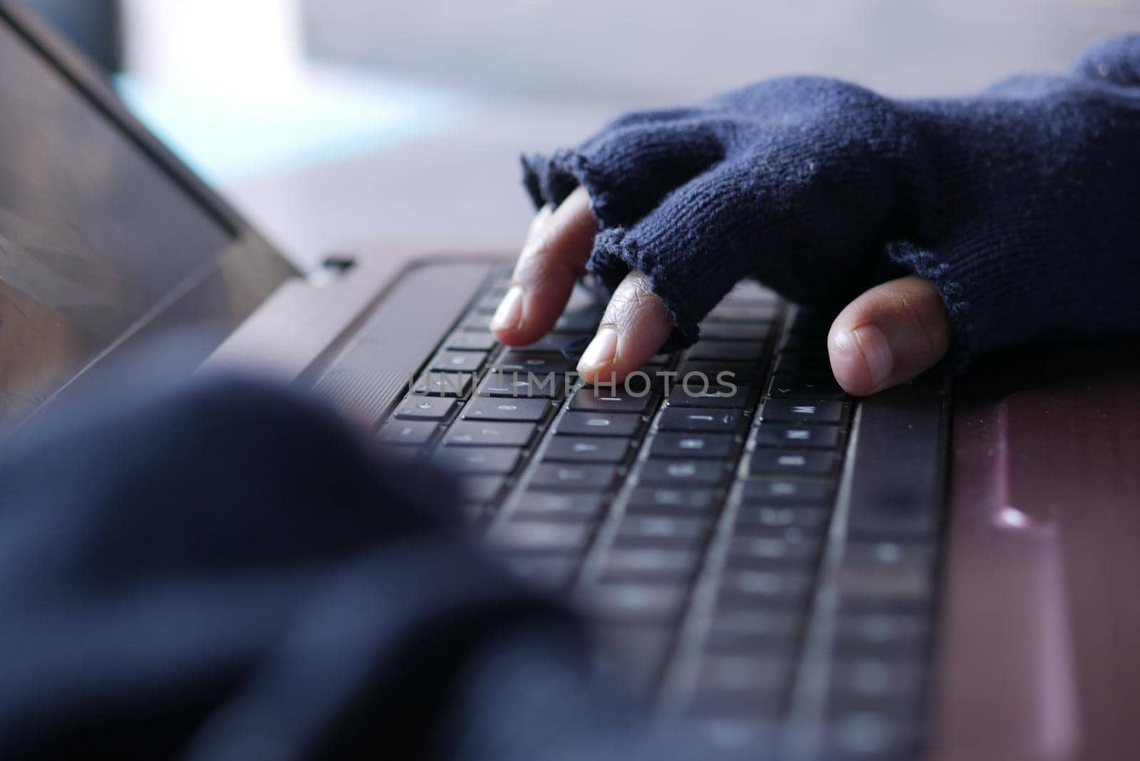 hacker hand stealing data from laptop top down.