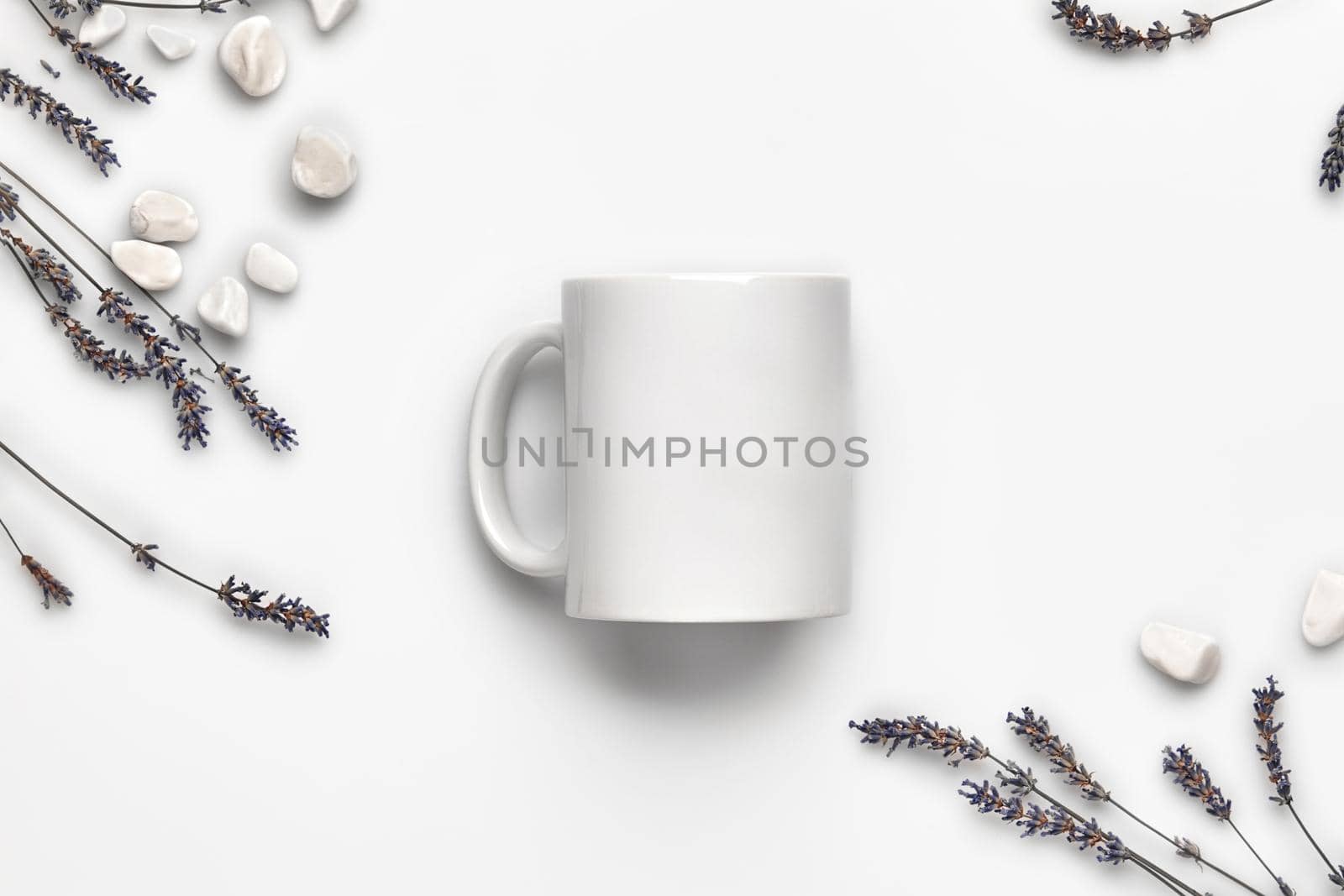 Cup with no logo, purple lavender flowers and small sea stones isolated on white background. Close up, copy space for your text or images. Mock up for your advertising. Top view, flat lay