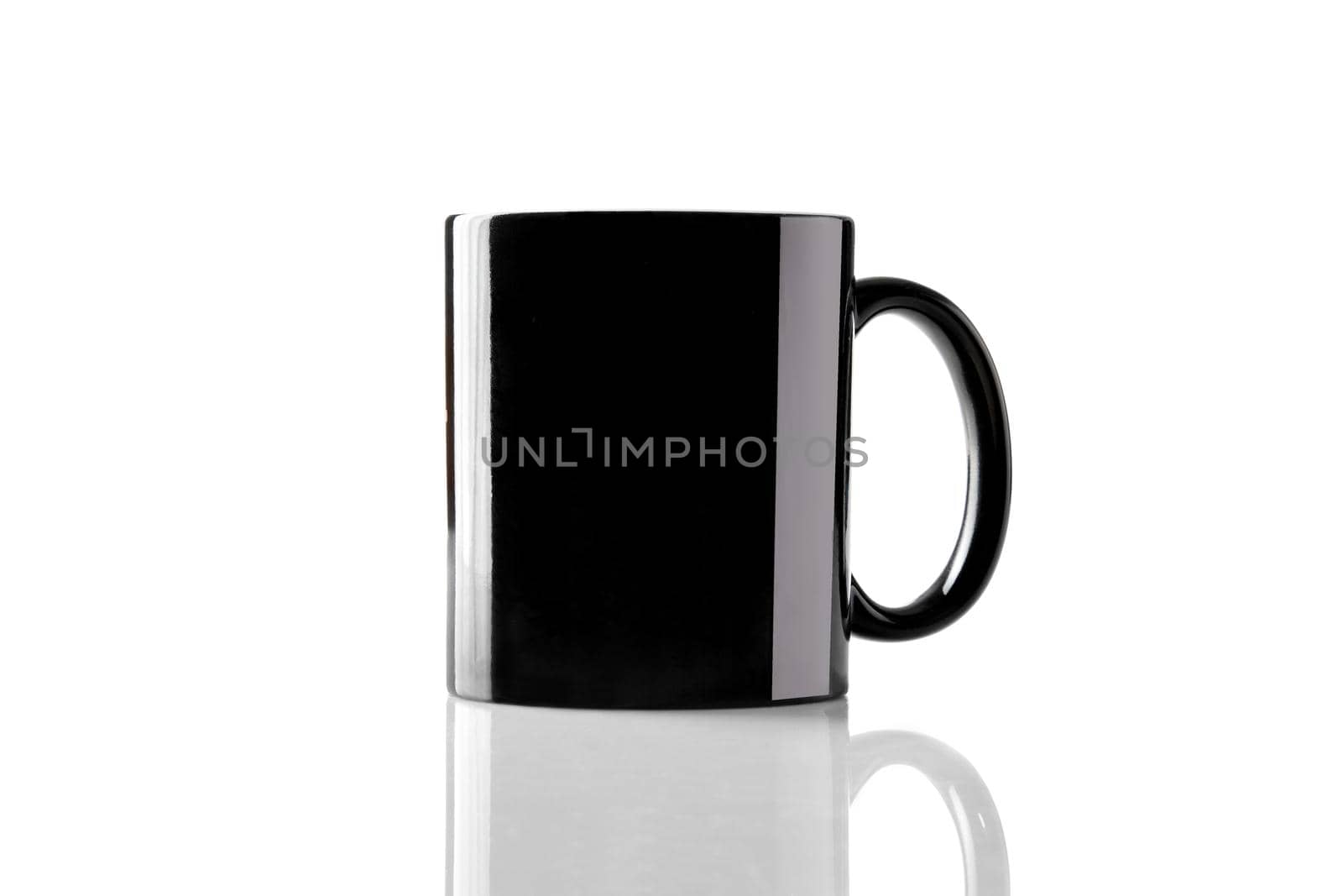 Black porcelain mug for coffee or tea on glossy surface isolated on white studio background. Mock up, template for advertising. Branding area. Close up, copy space for your text or images