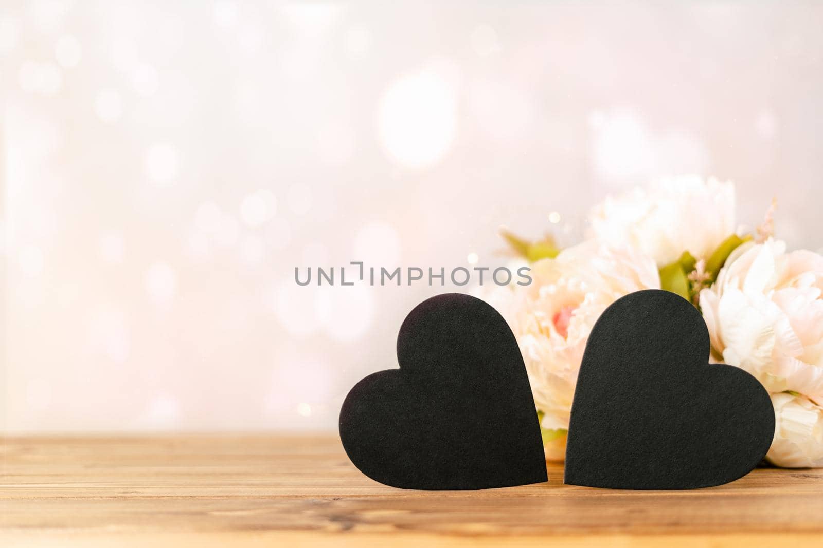 Still life pink Valentines day festive background with empty 2 black chalkboard heart and flowers on wooden table. Mockup with copy space for design.