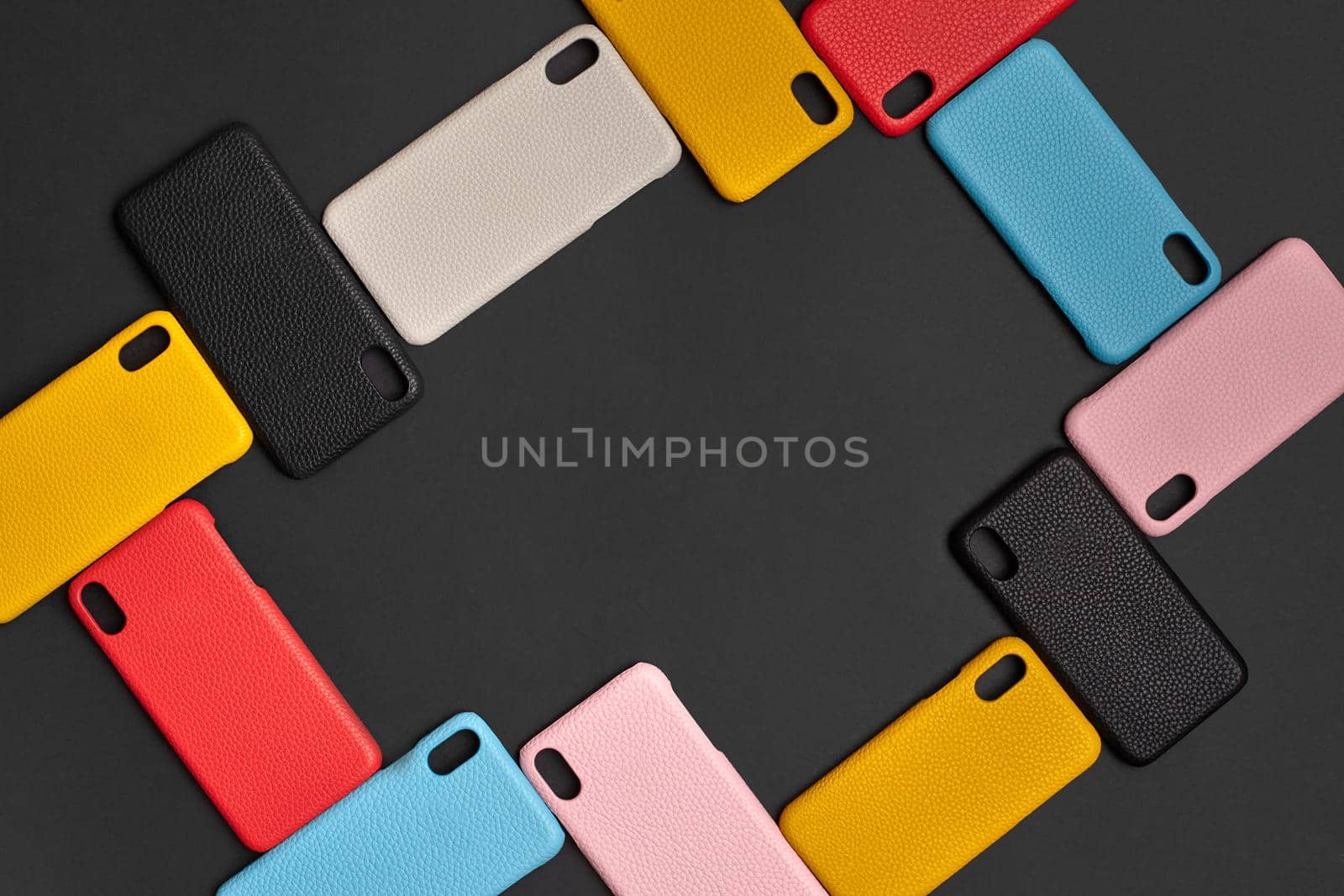 Set of colorful protective smartphone cases or covers on black studio background. Close up, copy space for your text or images. Top view, flat lay, mock up