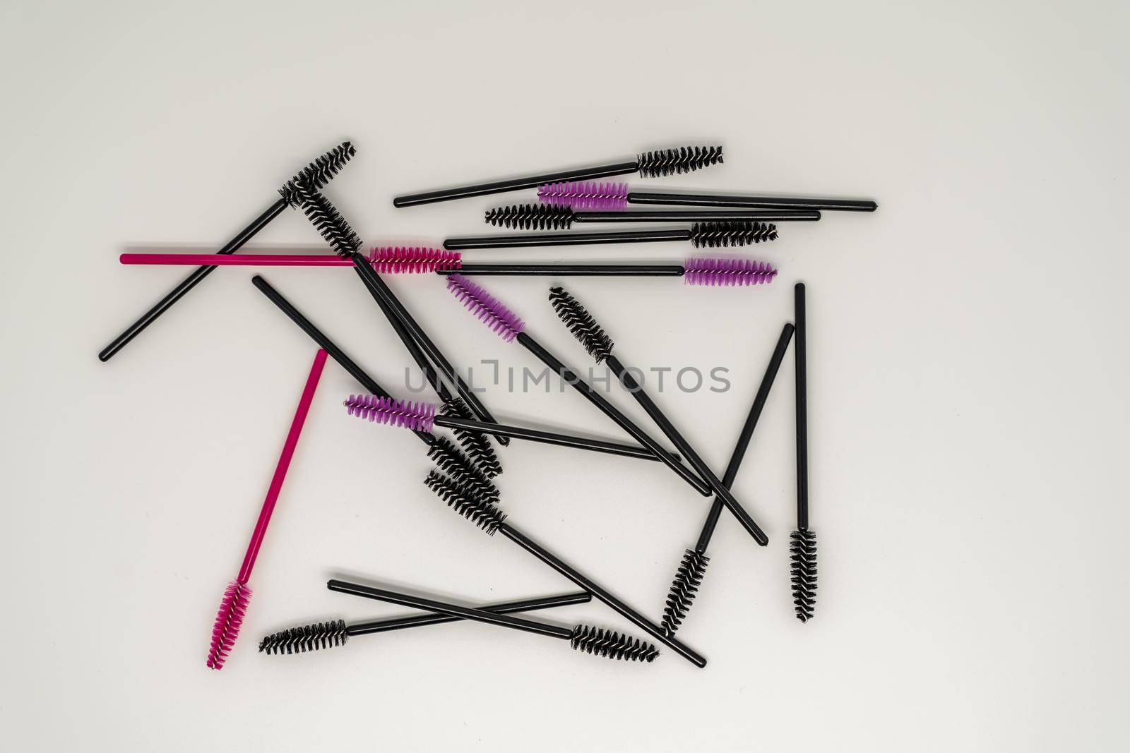 Makeup brushes, eyelash combs and eyebrows on white background with copy space.