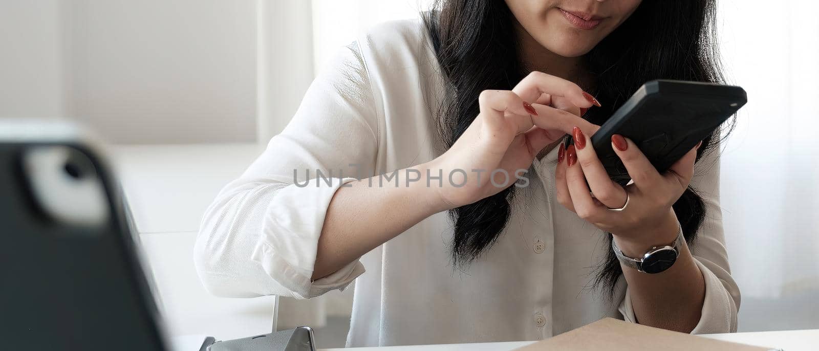 Close up image of an asian woman holding , using and looking at mobile phone