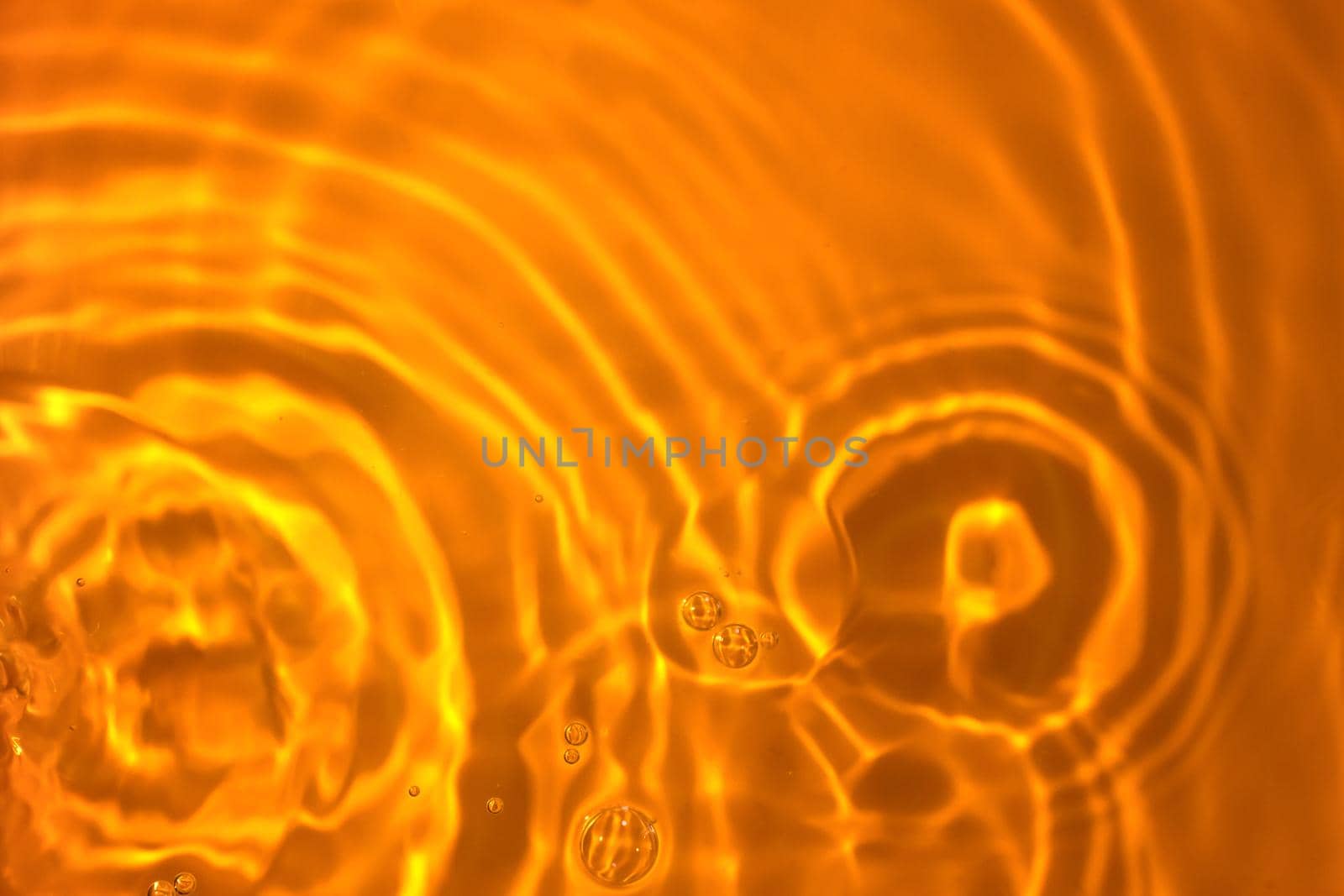 The texture of circles on water. Drops of liquid on orange background. Perfect backdrop for design projects. Summer holidays, laboratory analysis and research concept