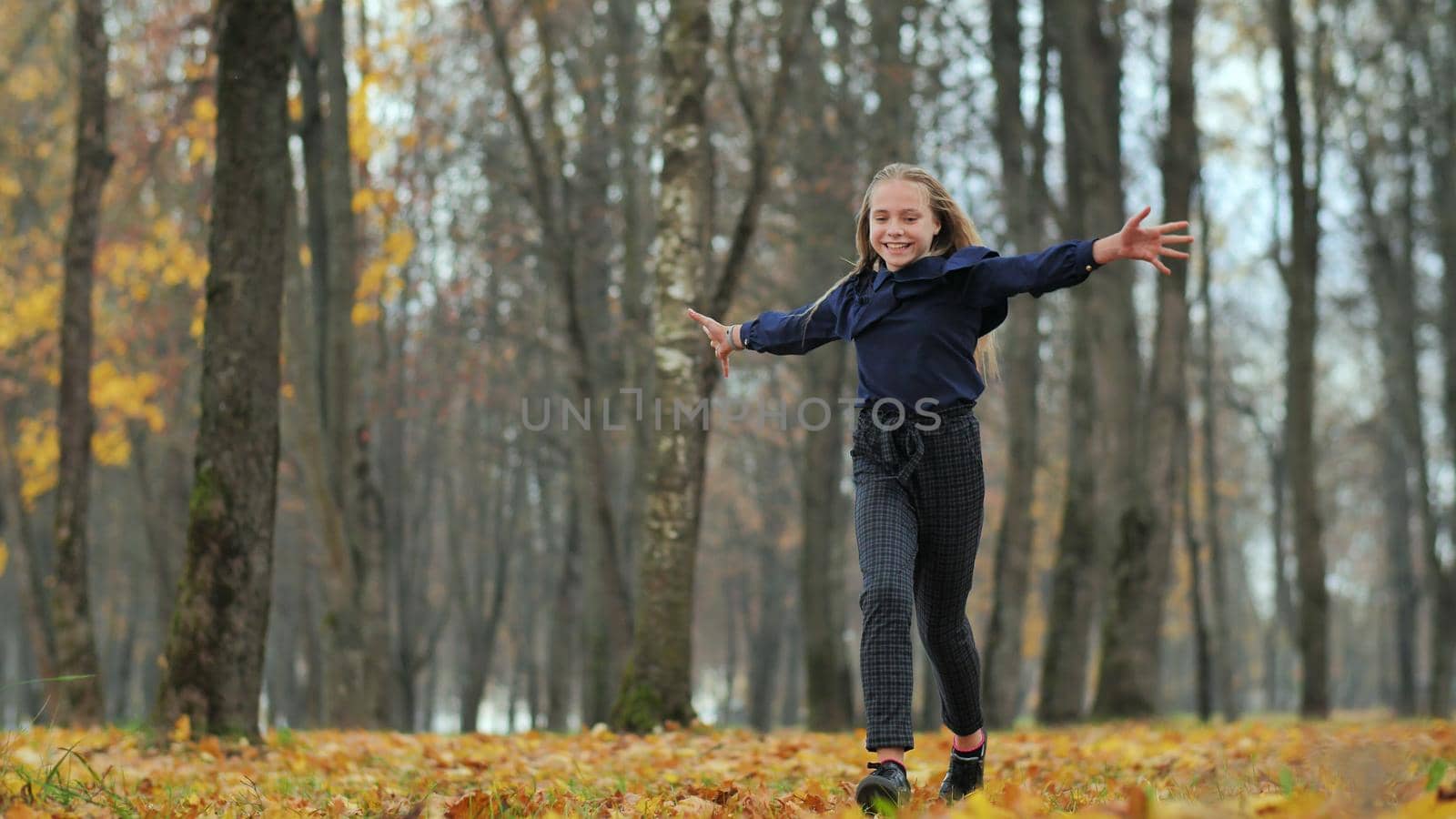 Happy teenage girl runs in the autumn park
