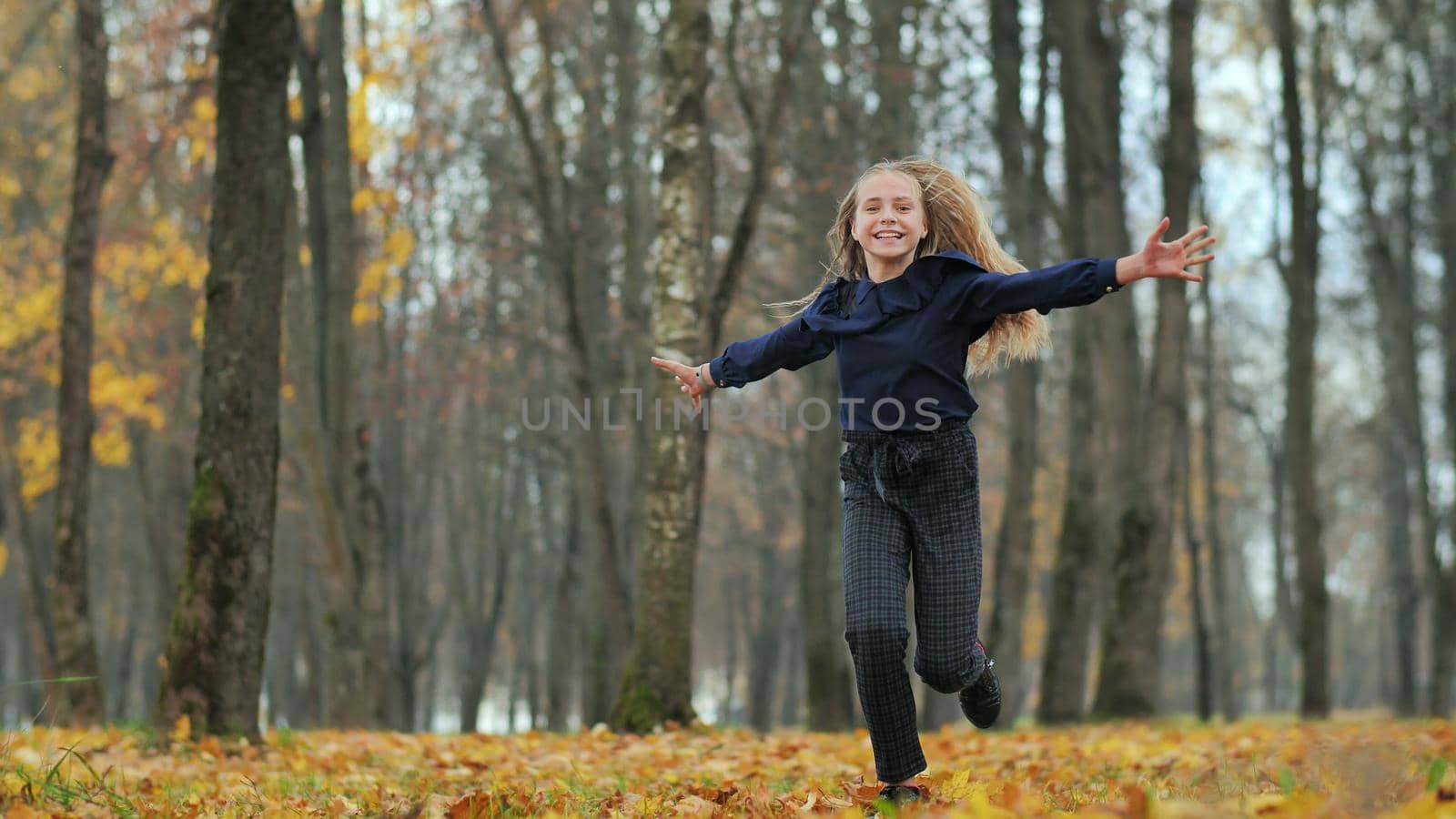 Happy teenage girl runs in the autumn park. by DovidPro