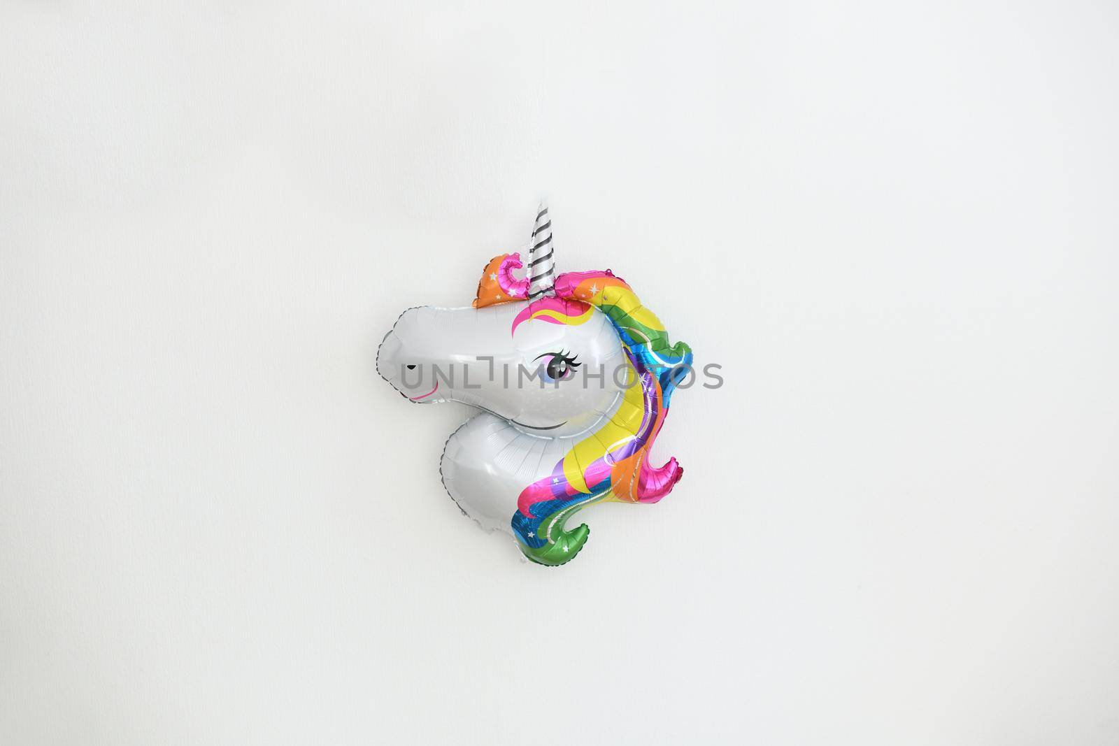 A inflatable unicorn hanging on the wall for birthday decoration